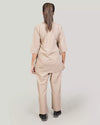 Person wearing a beige medical scrub set on a plain background