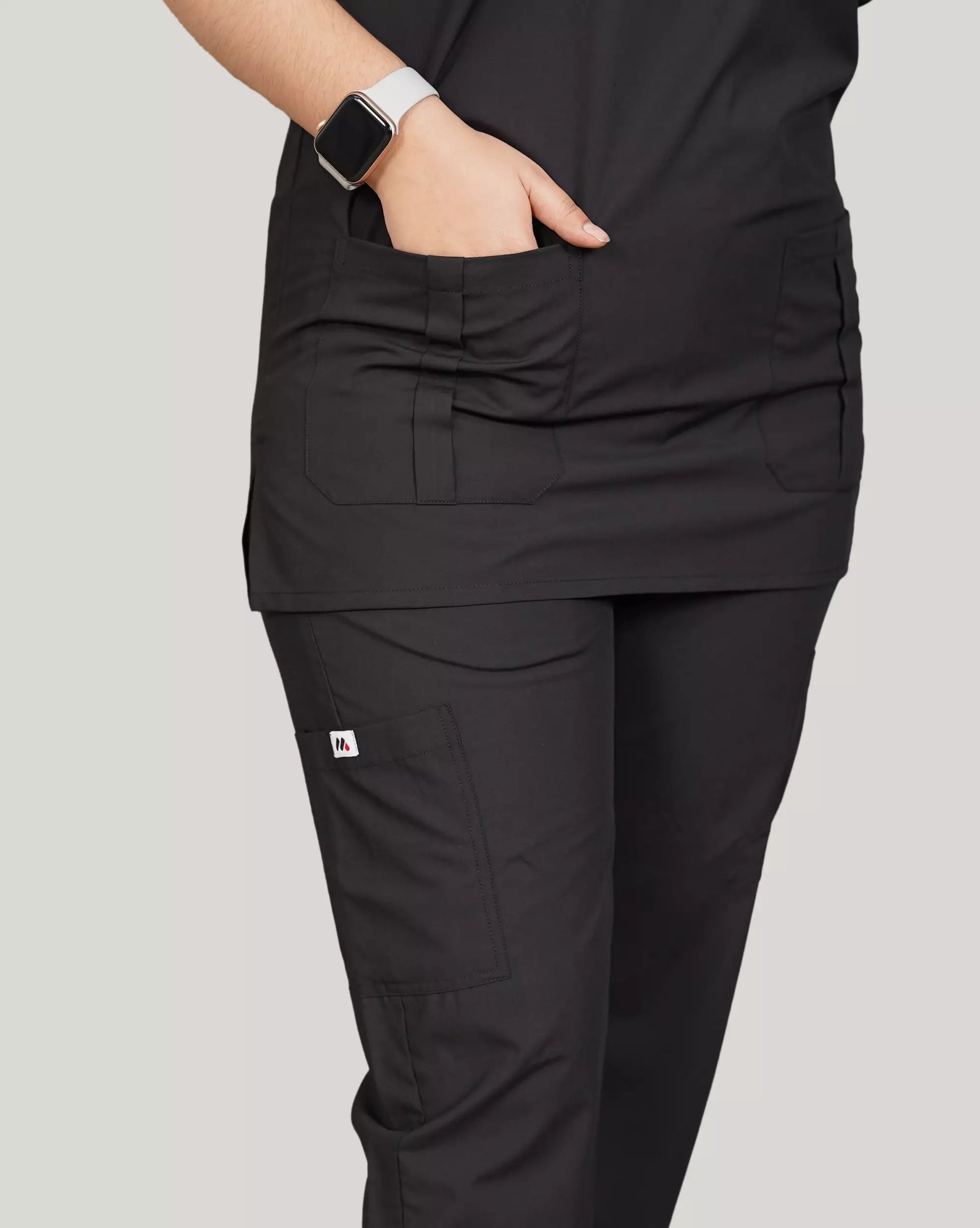 Close-up of a hand adjusting the sleeve of a burgundy Medfit unisex scrub top, highlighting the comfortable fabric and Medfit logo, suitable for medical and healthcare professionals.