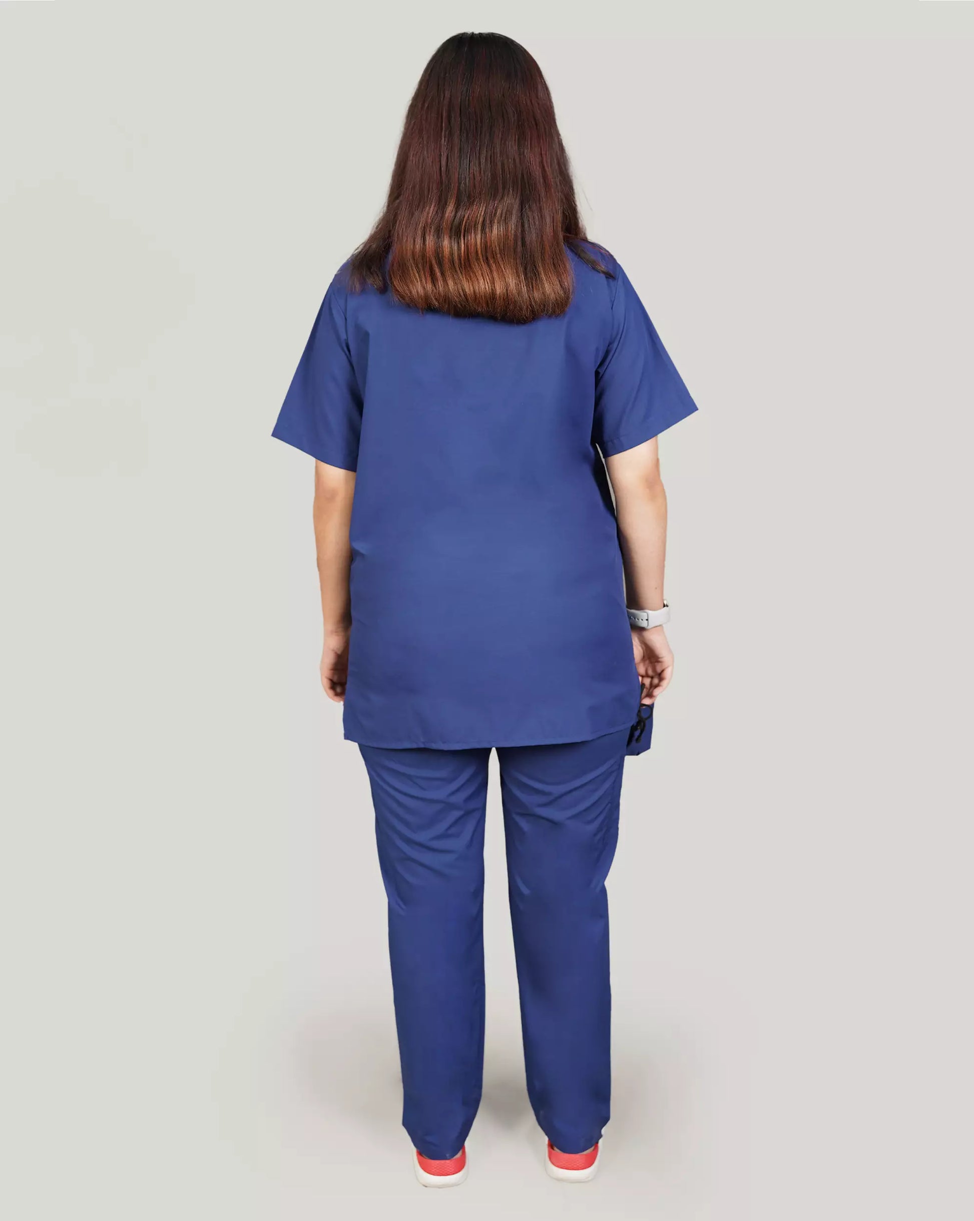 Rear view of a female medical professional in a royal blue Medfit Basic Unisex scrub set, showcasing the relaxed fit and uniform design for medical environments.