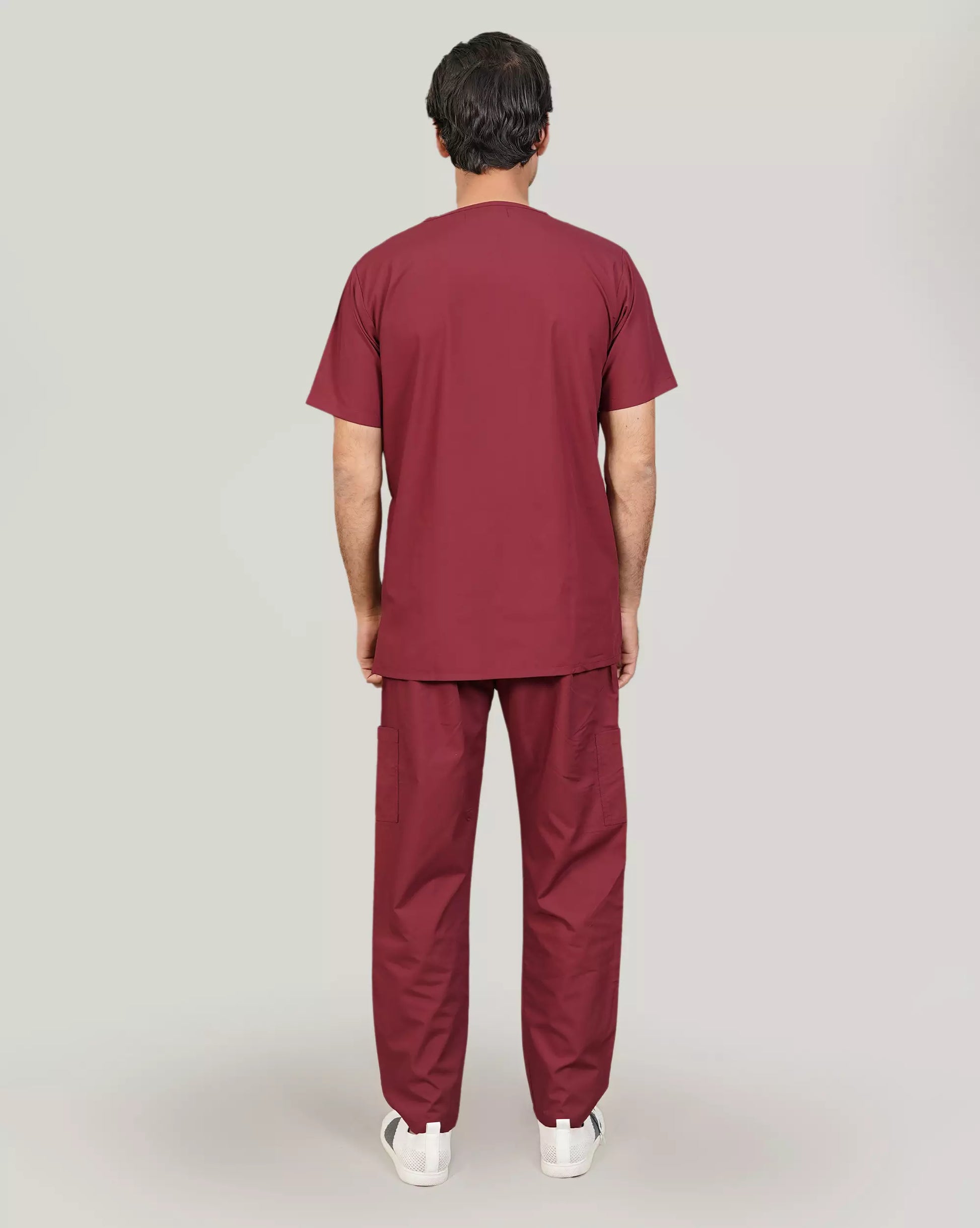 Rear view of a male medical professional in a burgundy Medfit men's scrub set, showcasing the comfortable and professional fit.