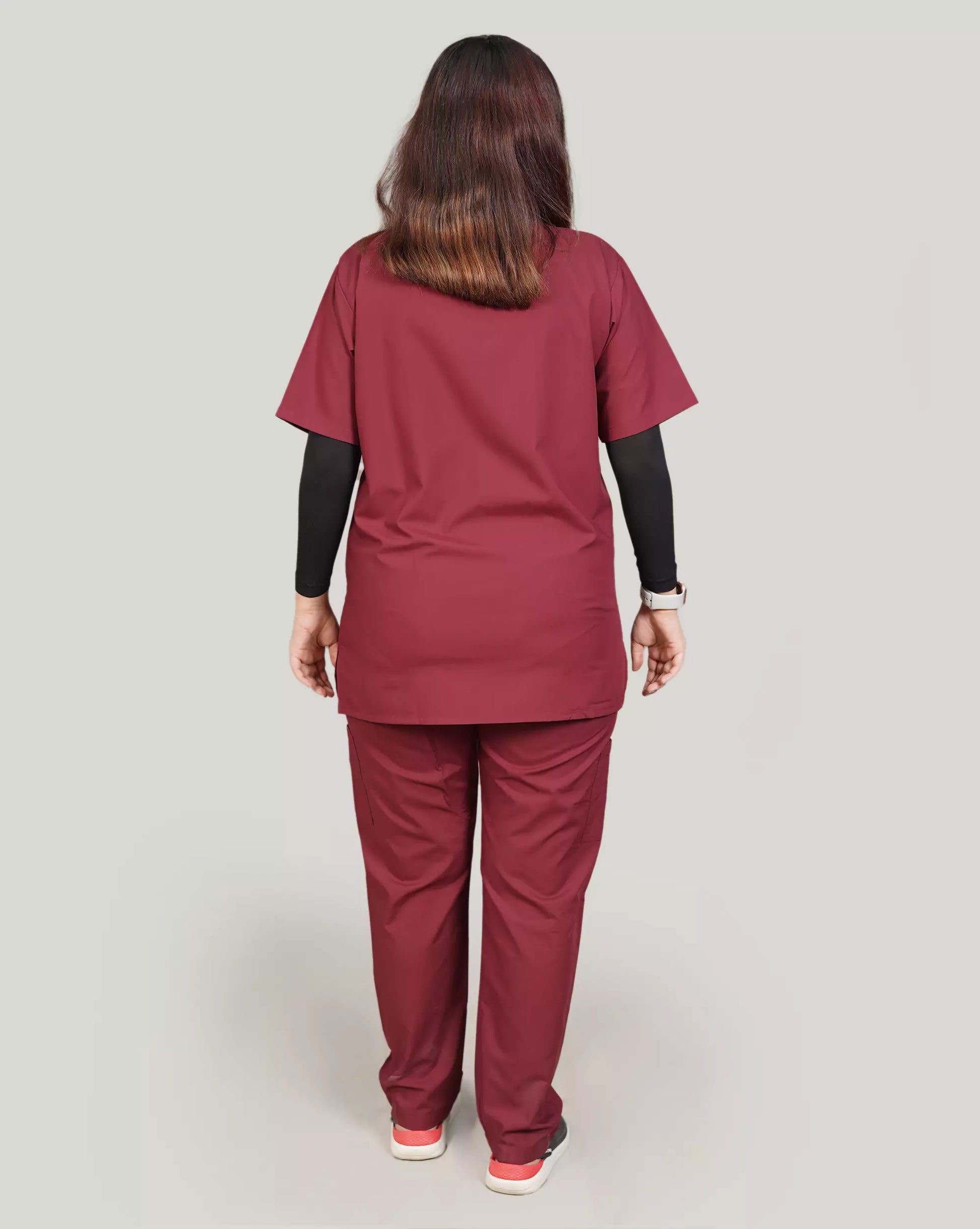 Full-body front view of a confident female medical professional in a complete basic grey Medfit unisex scrub set, emphasizing comfortable and professional medical attire
