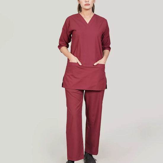 Person wearing a burgundy medical scrub set on a plain background