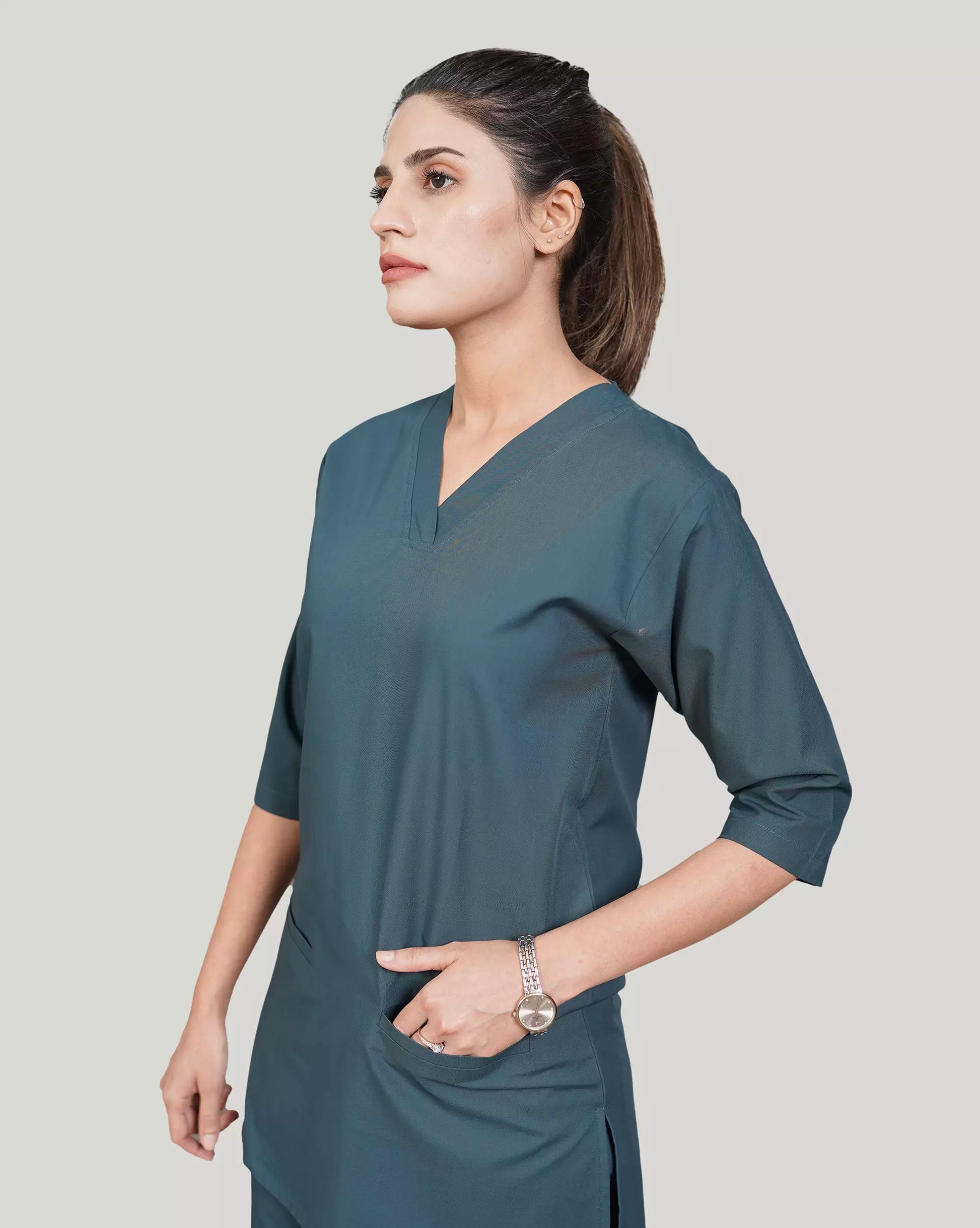 Woman wearing a teal dress against a plain background