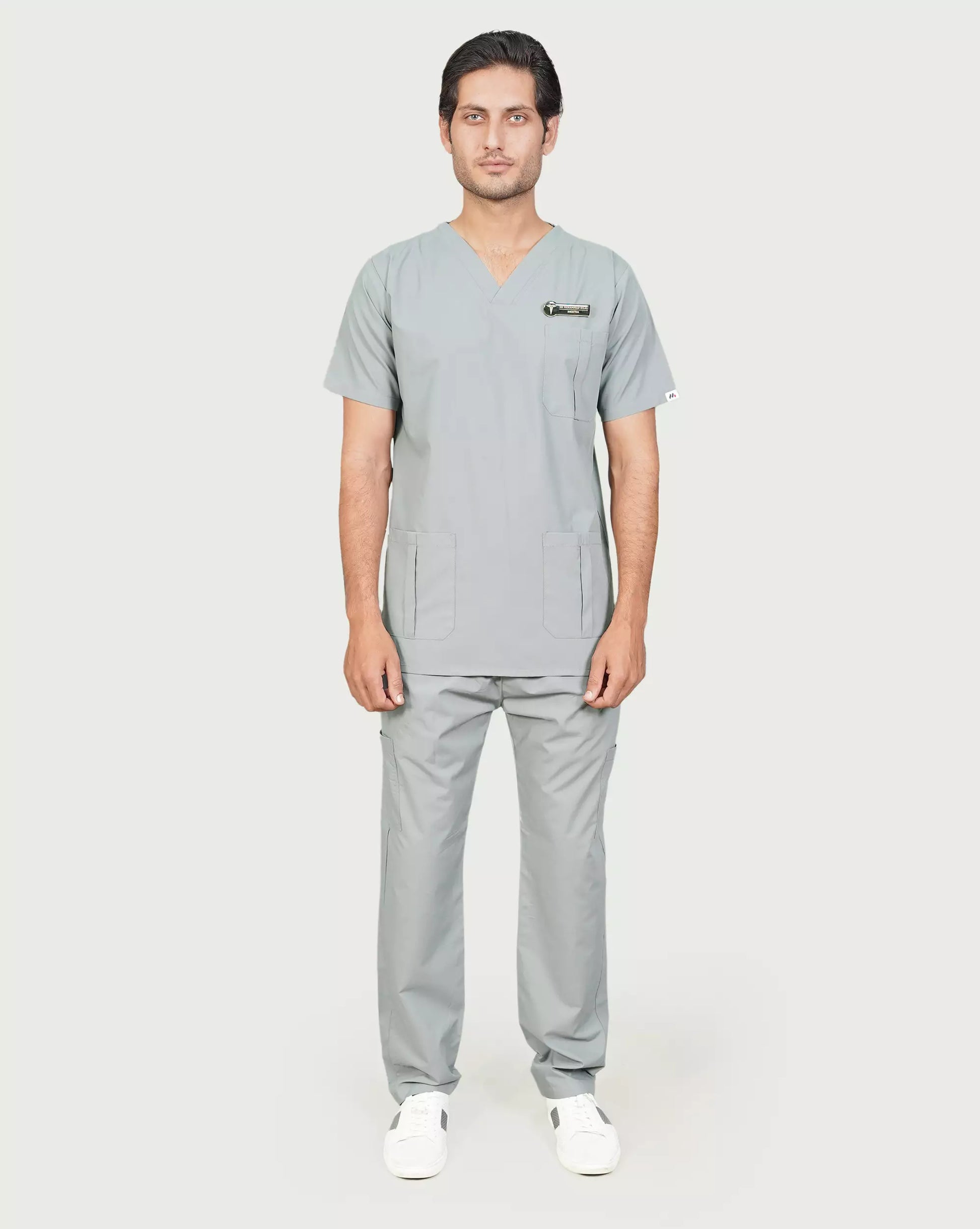 Full-body image of a male medical professional in a complete basic grey Medfit men's scrub set, offering a professional and comfortable uniform for healthcare environments.