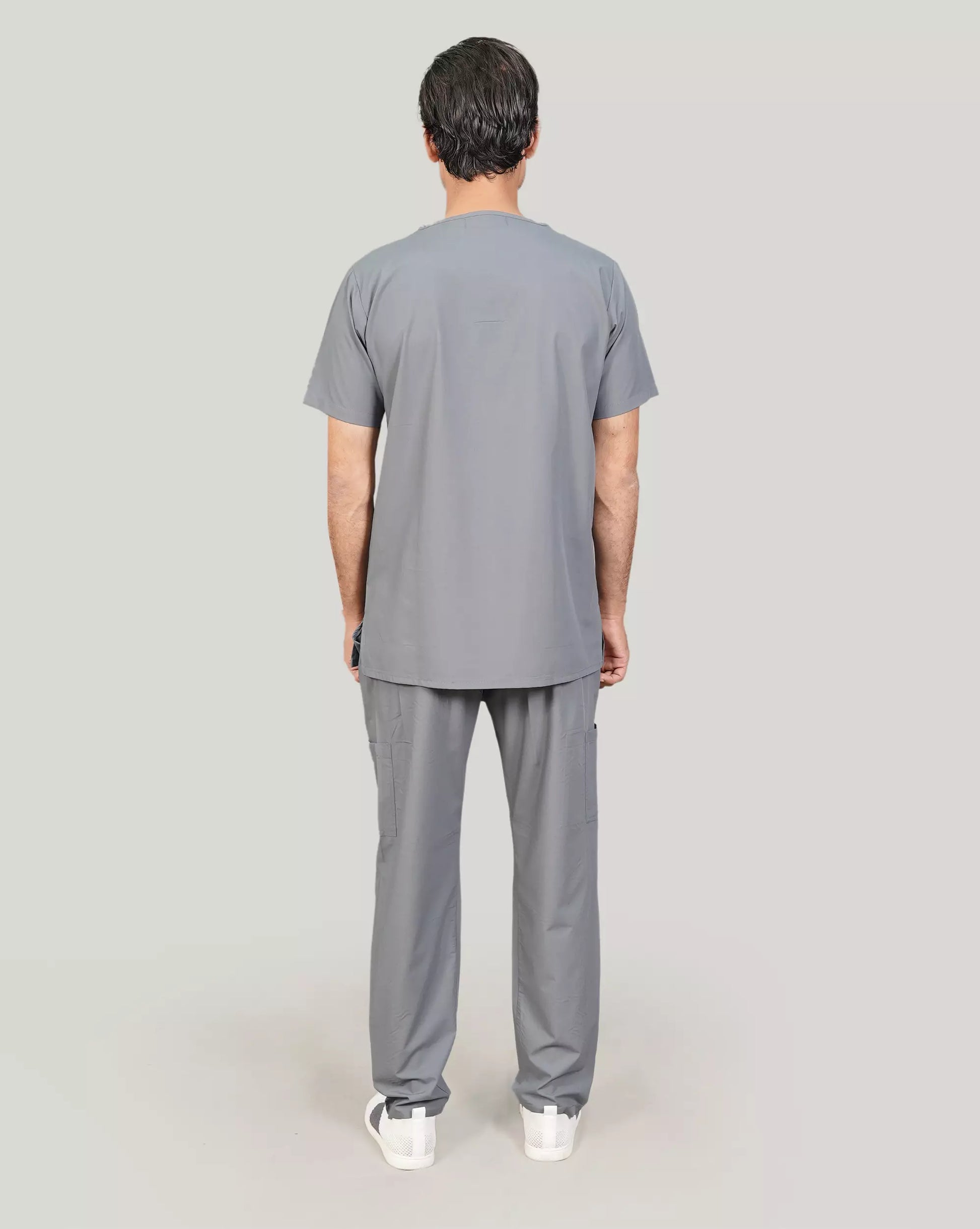 Rear view of a male medical professional in a basic grey Medfit men's scrub set, showcasing the relaxed fit and classic design suitable for medical work.