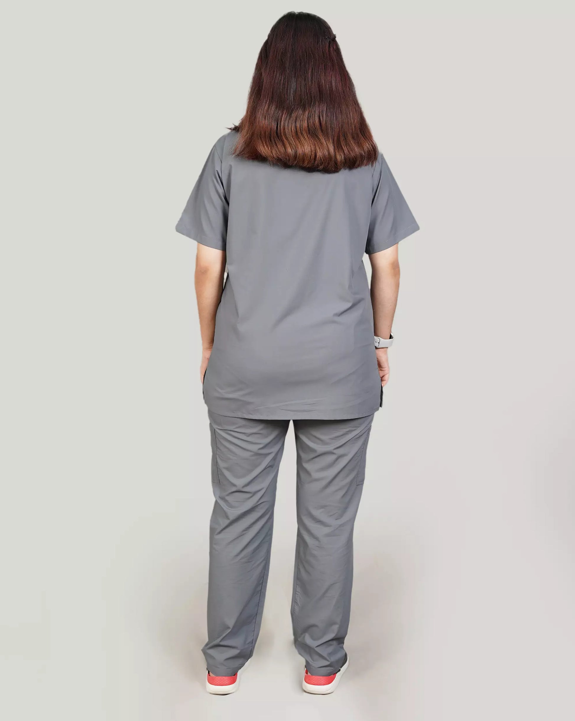 Rear view of a female medical professional in a basic grey Medfit unisex scrub set, highlighting the relaxed fit and durable fabric for medical work.