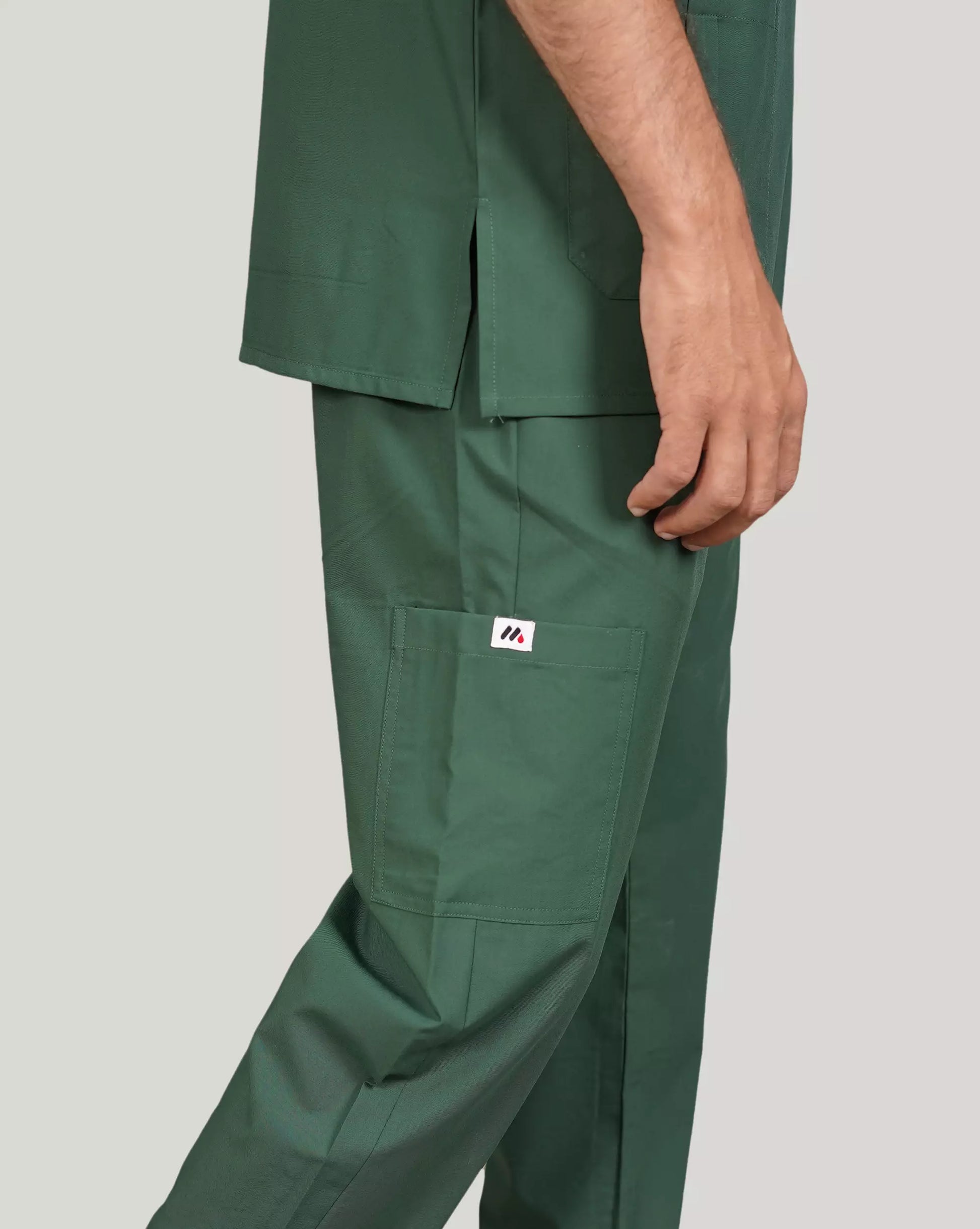 Detail shot of hunter green Medfit men's scrub pants, featuring a practical cargo pocket and the distinct Medfit logo, ideal for medical professionals.