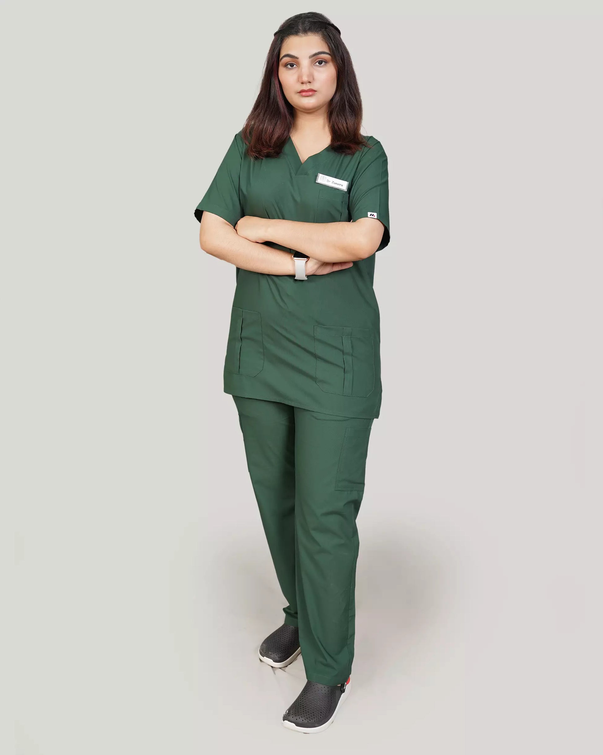 Full-body image of a female healthcare professional wearing a complete hunter green Medfit unisex scrub set, emphasizing comfort and professional style for medical environments.