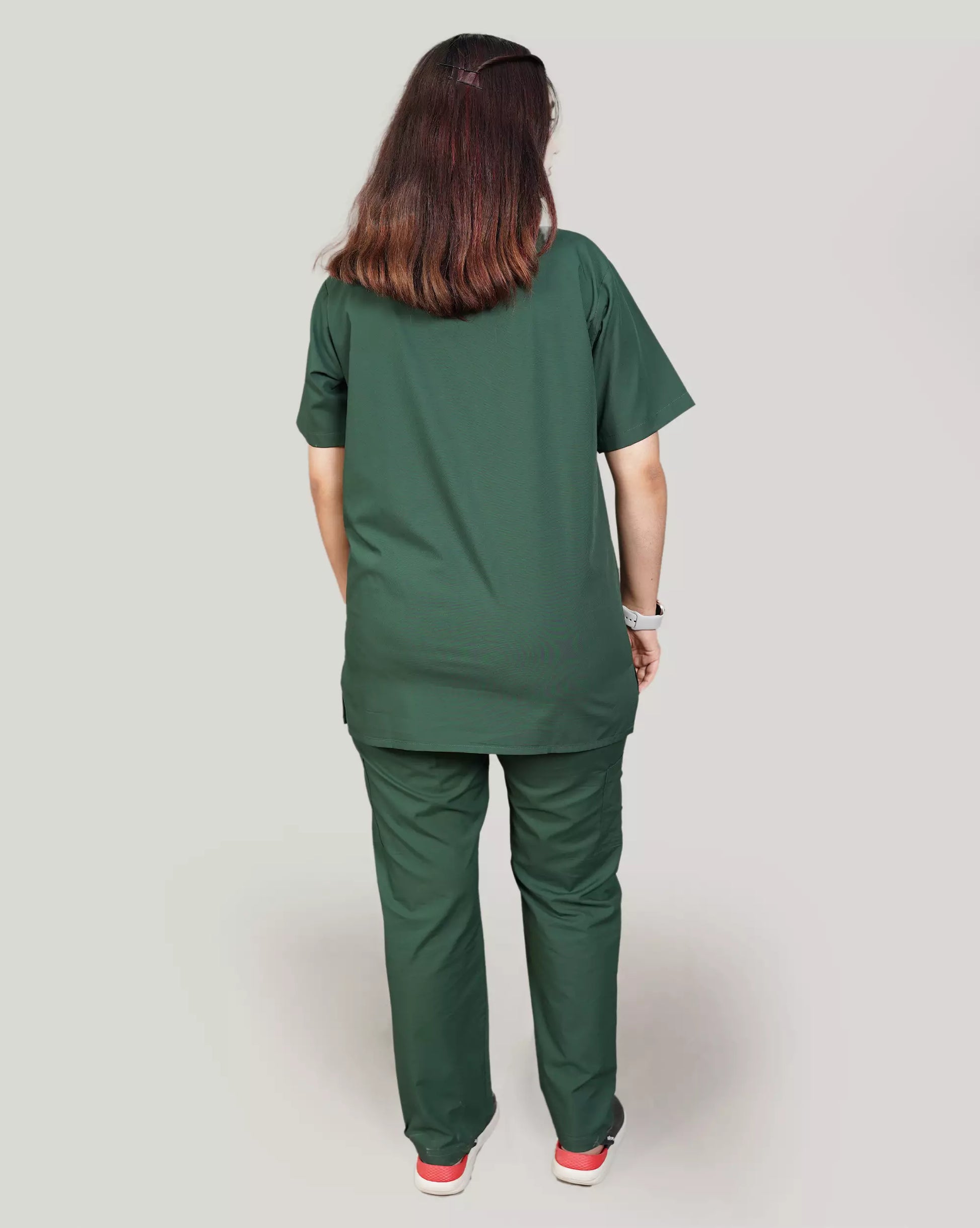 Rear view of a female medical professional in a hunter green Medfit unisex scrub set, highlighting the comfortable fit and professional appearance for healthcare.