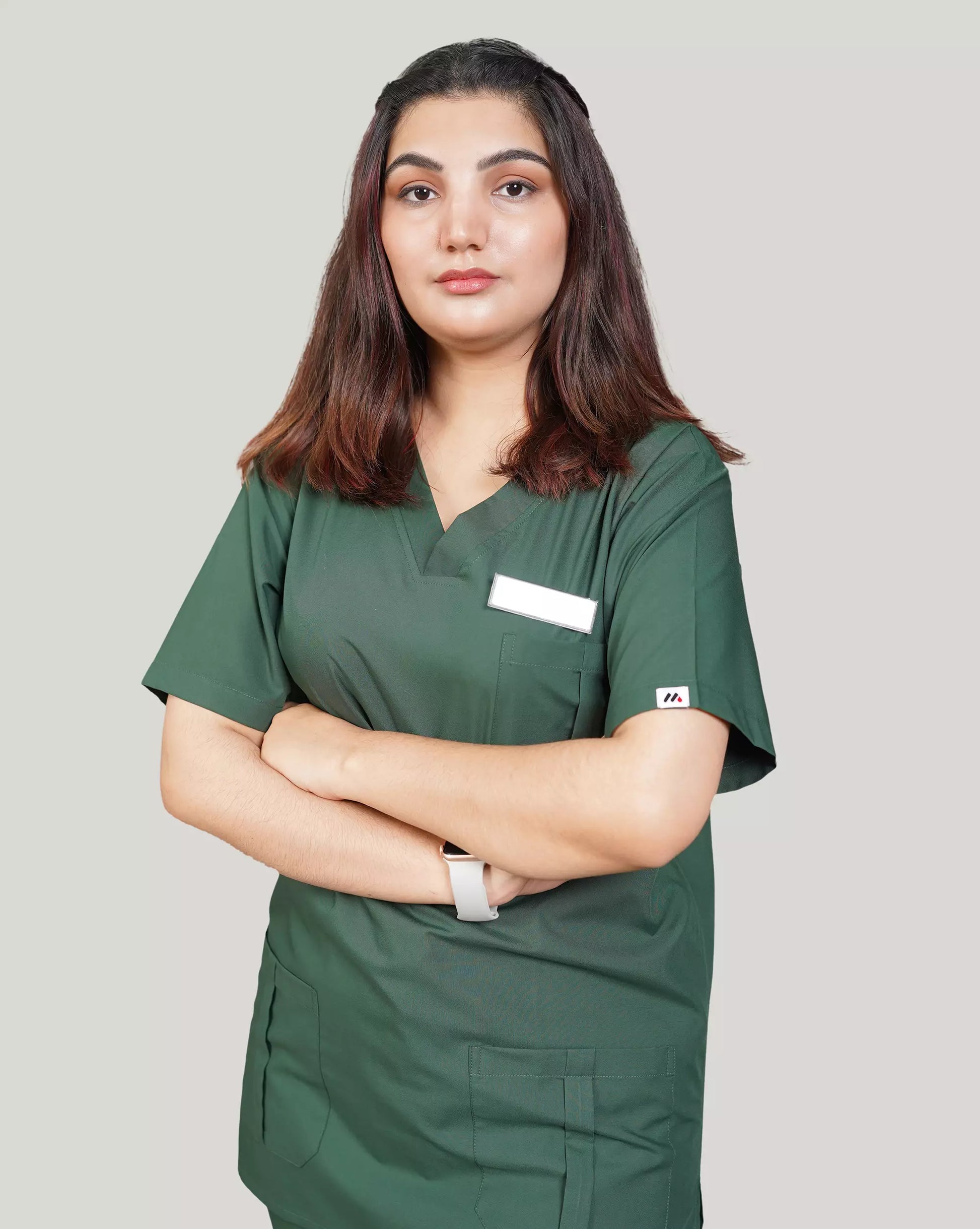 Confident female healthcare professional in a comfortable hunter green Medfit unisex scrub top, designed for both men and women in medical fields.