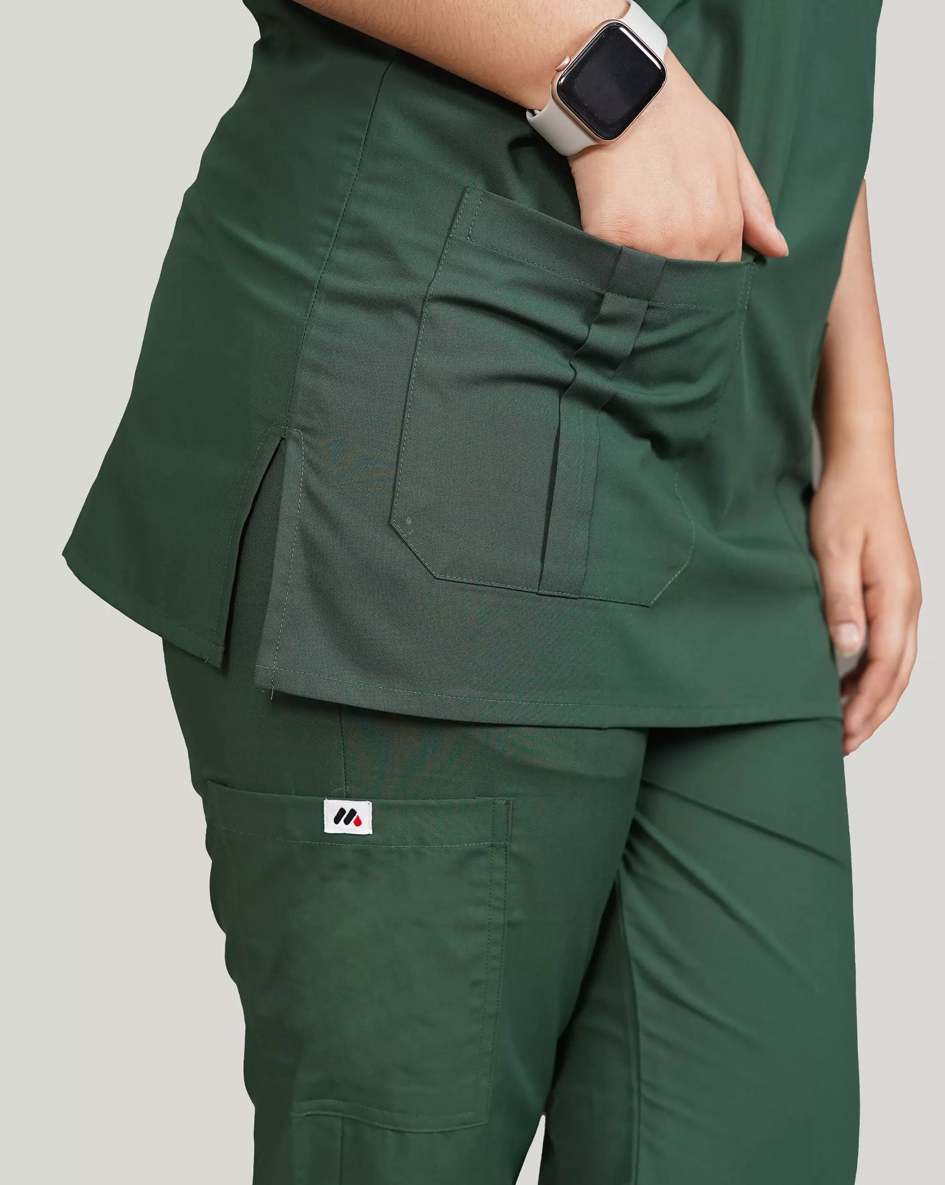 Close-up of a hunter green Medfit unisex scrub top and pants, highlighting functional pockets and the Medfit logo for medical professionals.