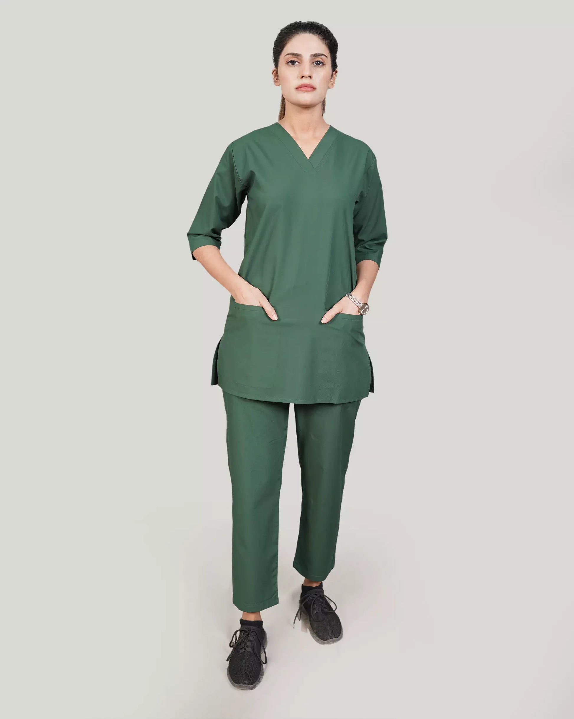 Person wearing a green medical scrub set on a plain background