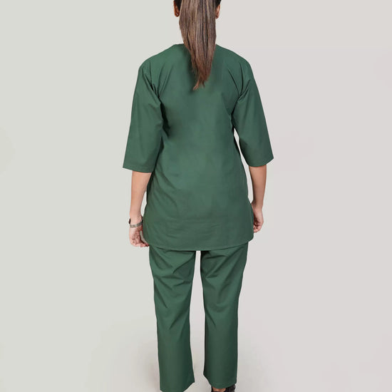 Person wearing a green medical scrub set on a plain background