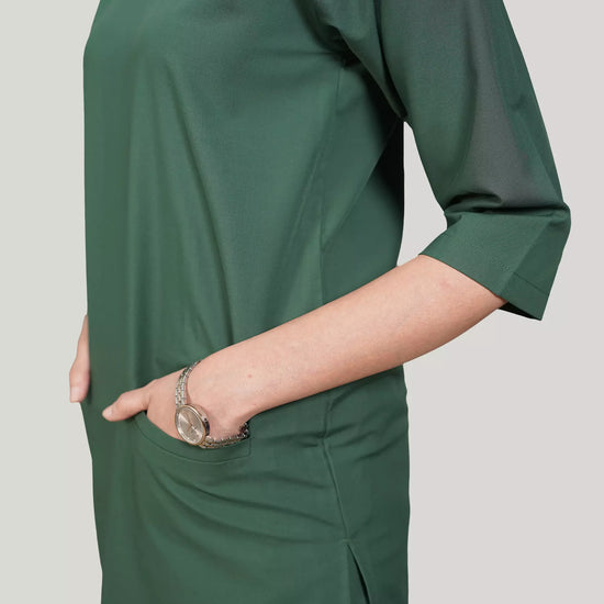 Green dress worn by a person on a plain background