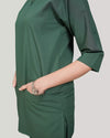 Green dress worn by a person on a plain background
