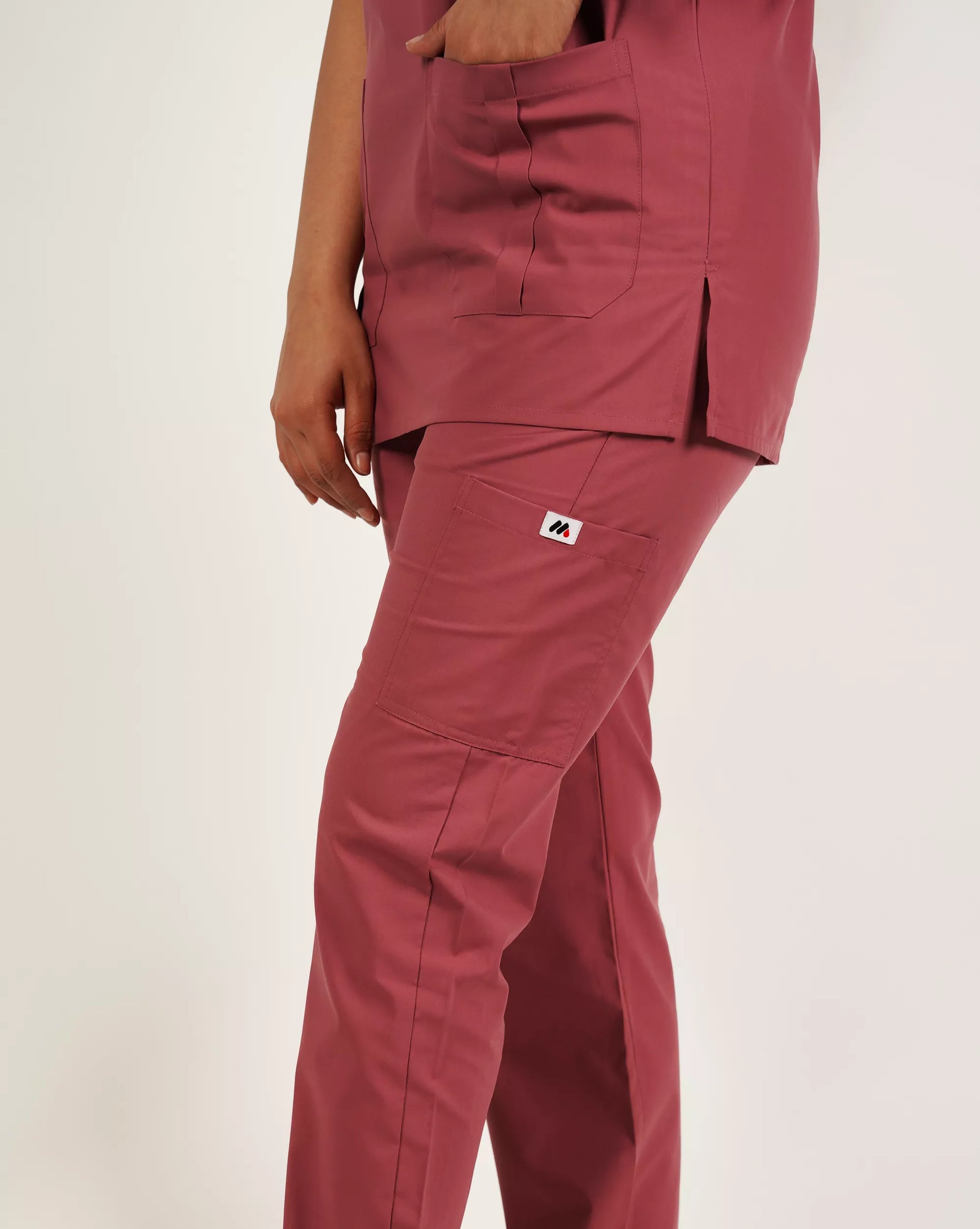 Close-up of basic pink Medfit women's scrub pants, highlighting the practical pocket and side slit details for comfort and mobility in healthcare settings.