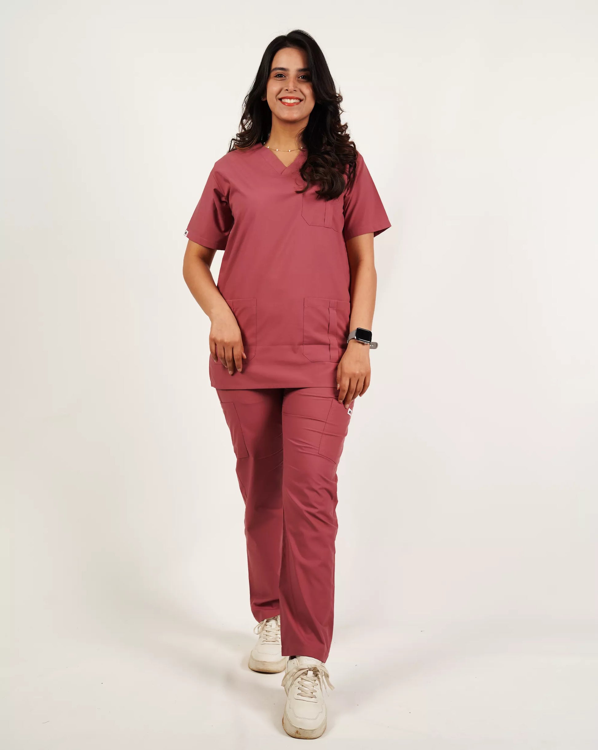 Front view of a smiling female medical professional in a complete basic pink Medfit women's scrub set, offering both style and functionality for demanding work environments.