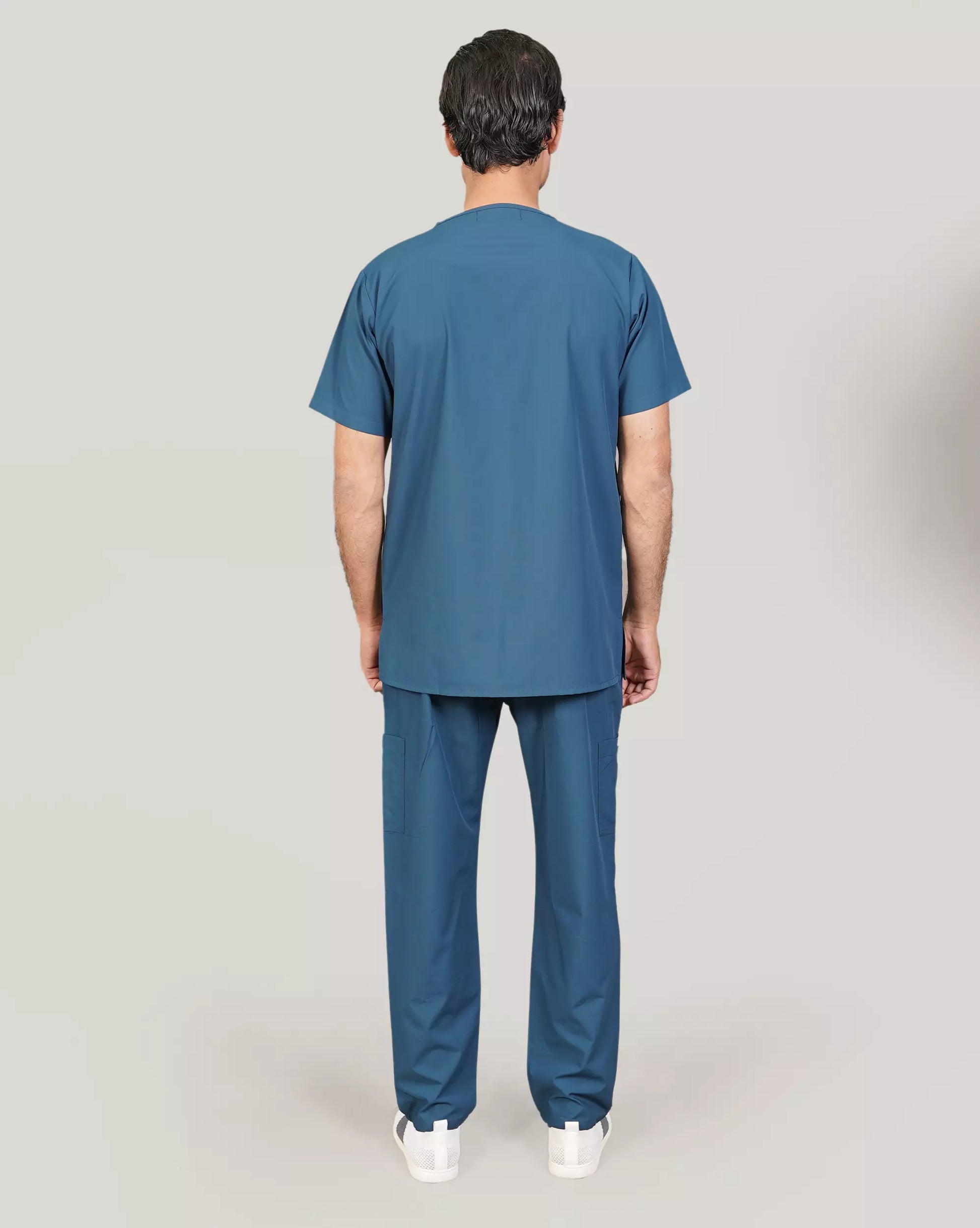 Rear view of a male medical professional in a basic blue 'Zinc' Medfit men's scrub set, highlighting the comfortable fit and durable fabric.