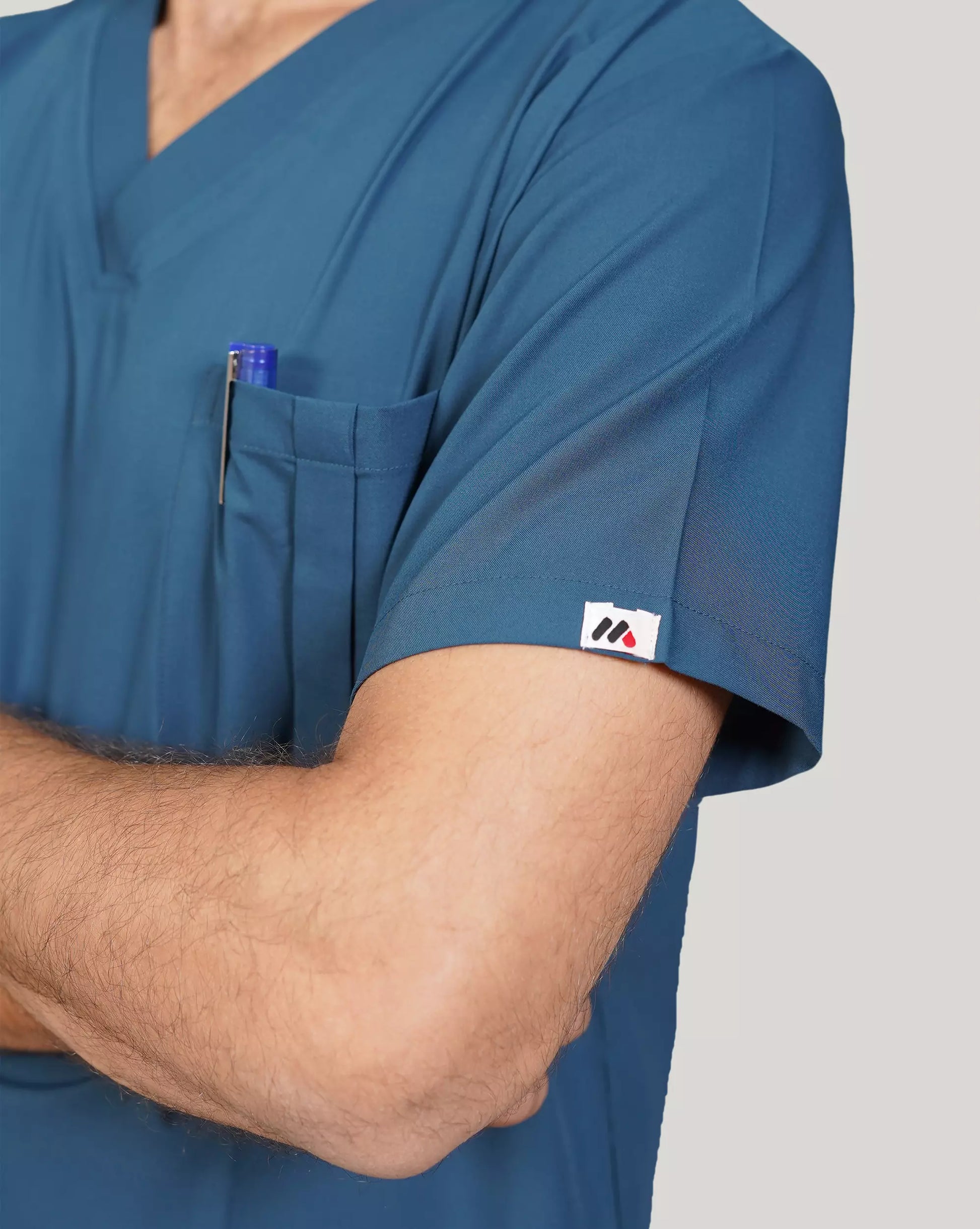 Close-up of a female healthcare professional in a sage green Medfit scrub top, with a stethoscope and smiling, ideal for medical or dental professionals.