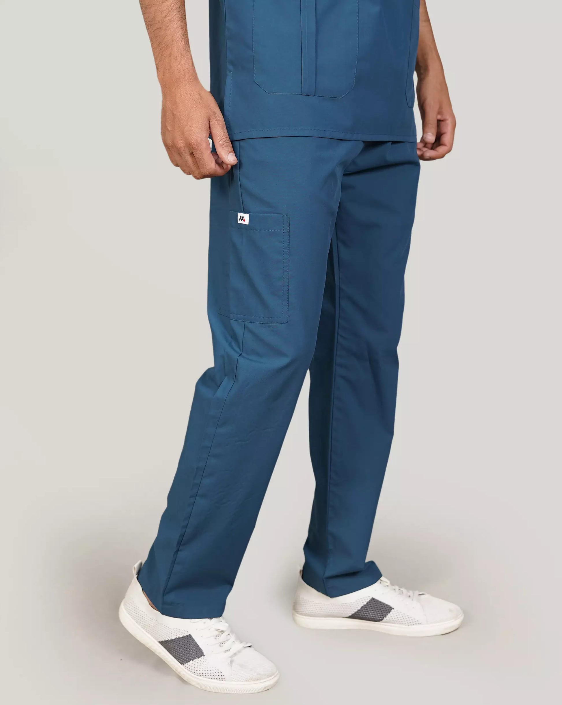 Rear view of a male medical professional in a beige Medfit men's scrub set, showcasing the relaxed fit and uniform design for medical environments.