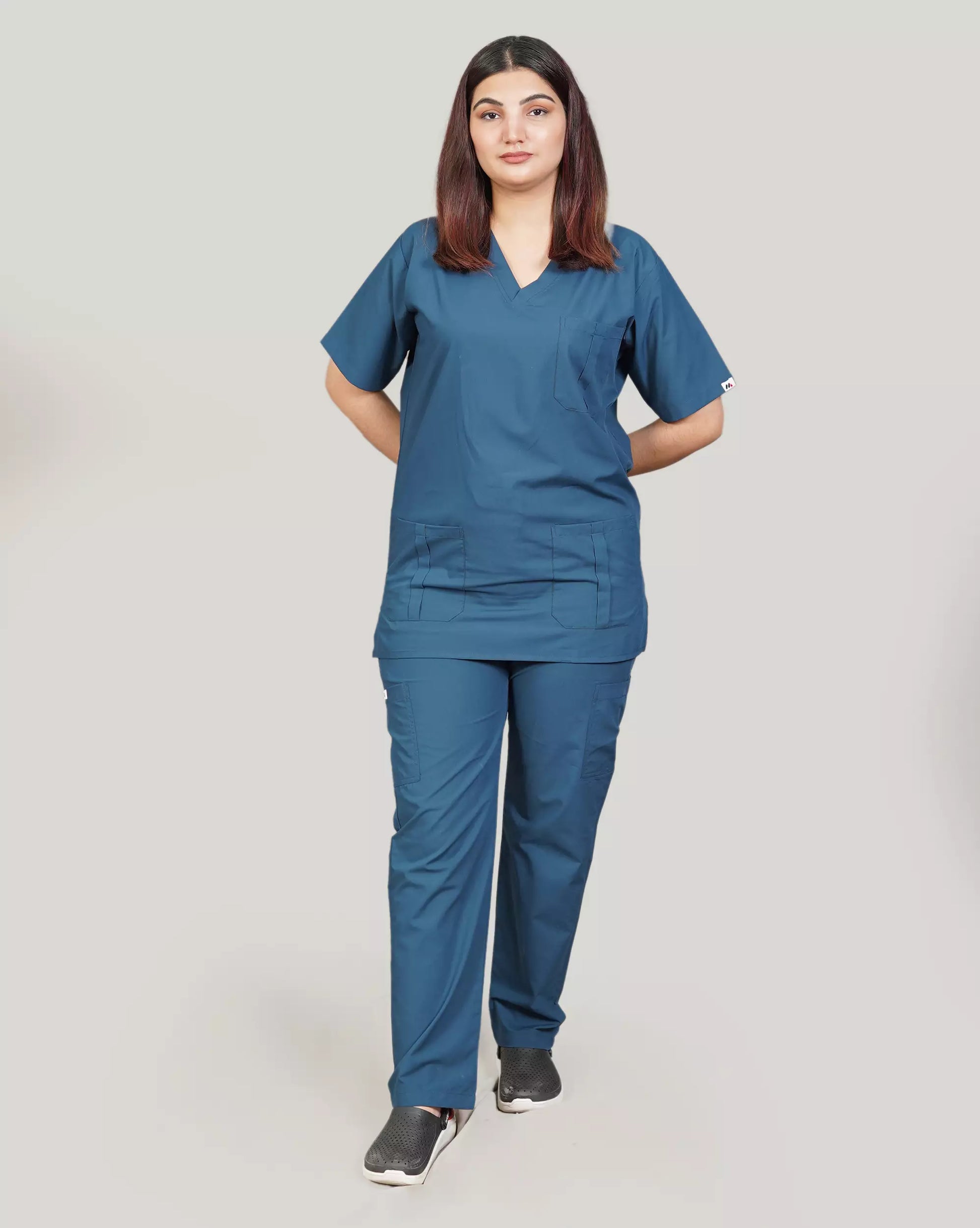 Full-body front view of a female medical professional in a basic blue 'Zinc' Medfit unisex scrub set, designed for comfort and durability in healthcare settings.