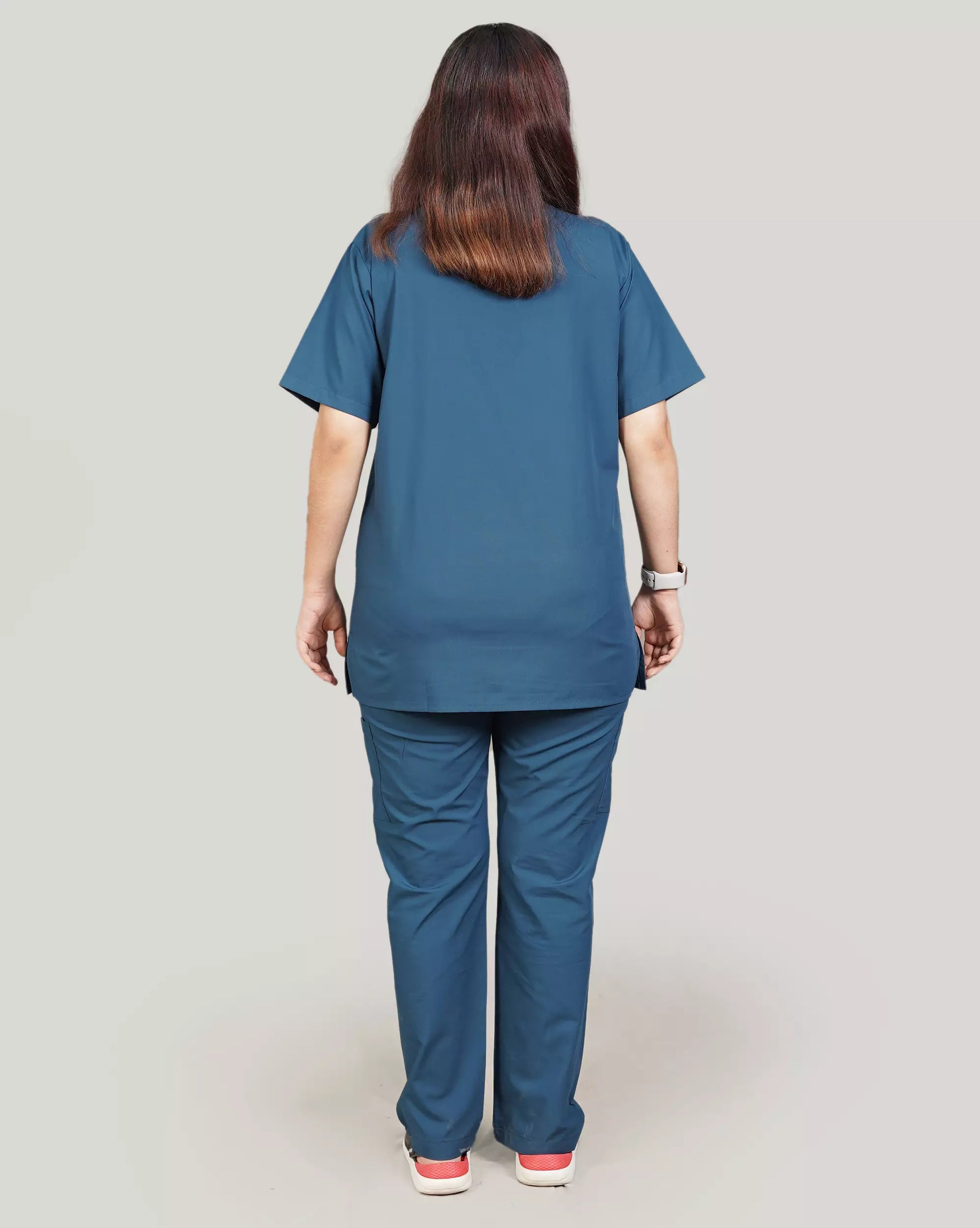 Rear view of a female medical professional in a basic blue 'Zinc' Medfit unisex scrub set, designed for comfort and mobility in busy healthcare environments.