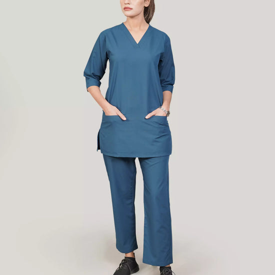 female doctor wearing a blue scrub set on a plain background