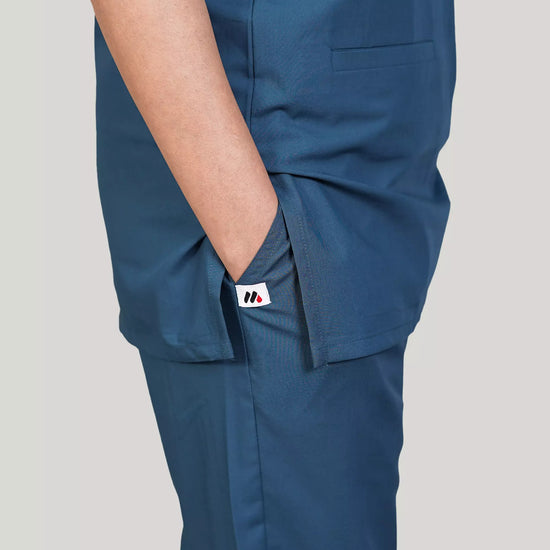 Blue scrub pants worn by a female doctor on a plain background