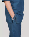 Blue scrub pants worn by a female doctor on a plain background