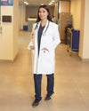 A person of indeterminate gender wearing a white, unisex lab coat with half sleeves and multiple pockets.