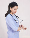 Healthcare professional in blue scrubs with stethoscope, checking wristwatch on white background.