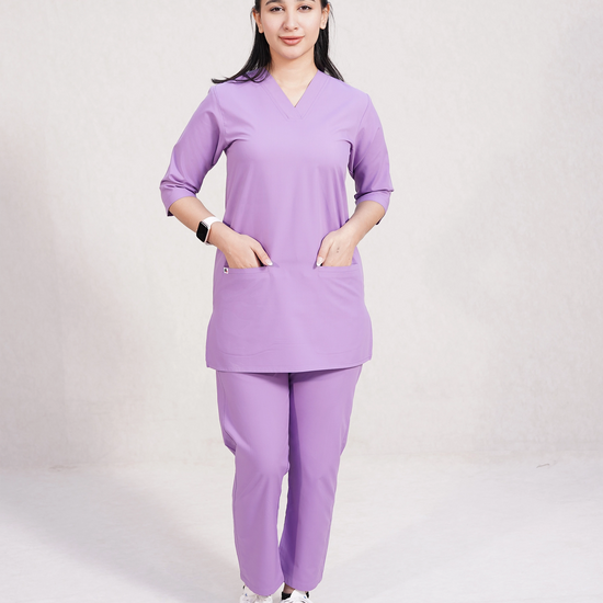 Person wearing a purple scrub set on a plain background