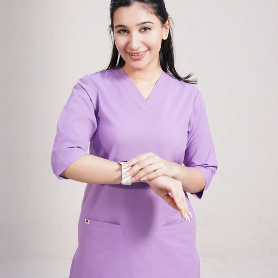 Person wearing purple medical scrubs on a plain background