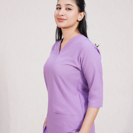 women wearing a purple scrub set on a plain background