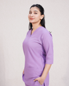 women wearing a purple scrub set on a plain background