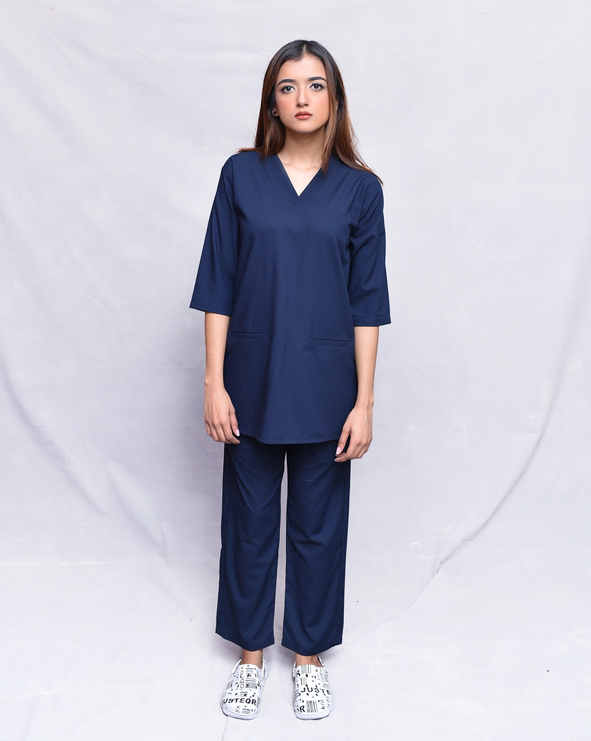 Woman wearing a navy blue outfit against a white background