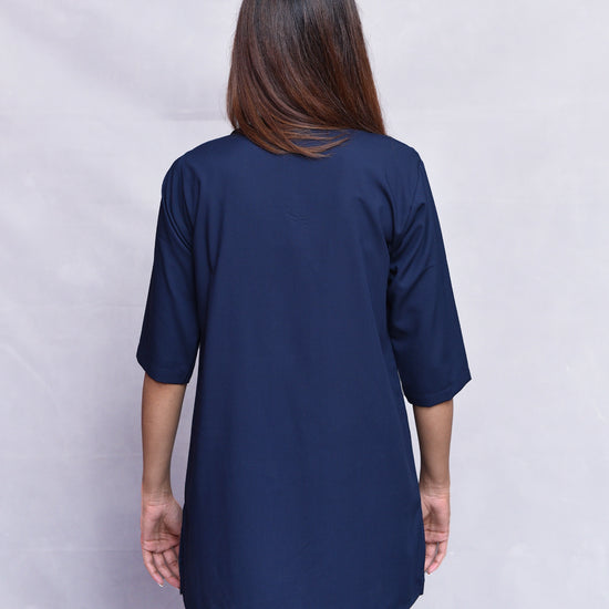 Person wearing a navy blue kurta and pants set against a plain background.