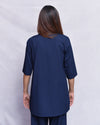 Person wearing a navy blue kurta and pants set against a plain background.