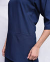 Navy blue scrub top with a pocket, worn by a person.