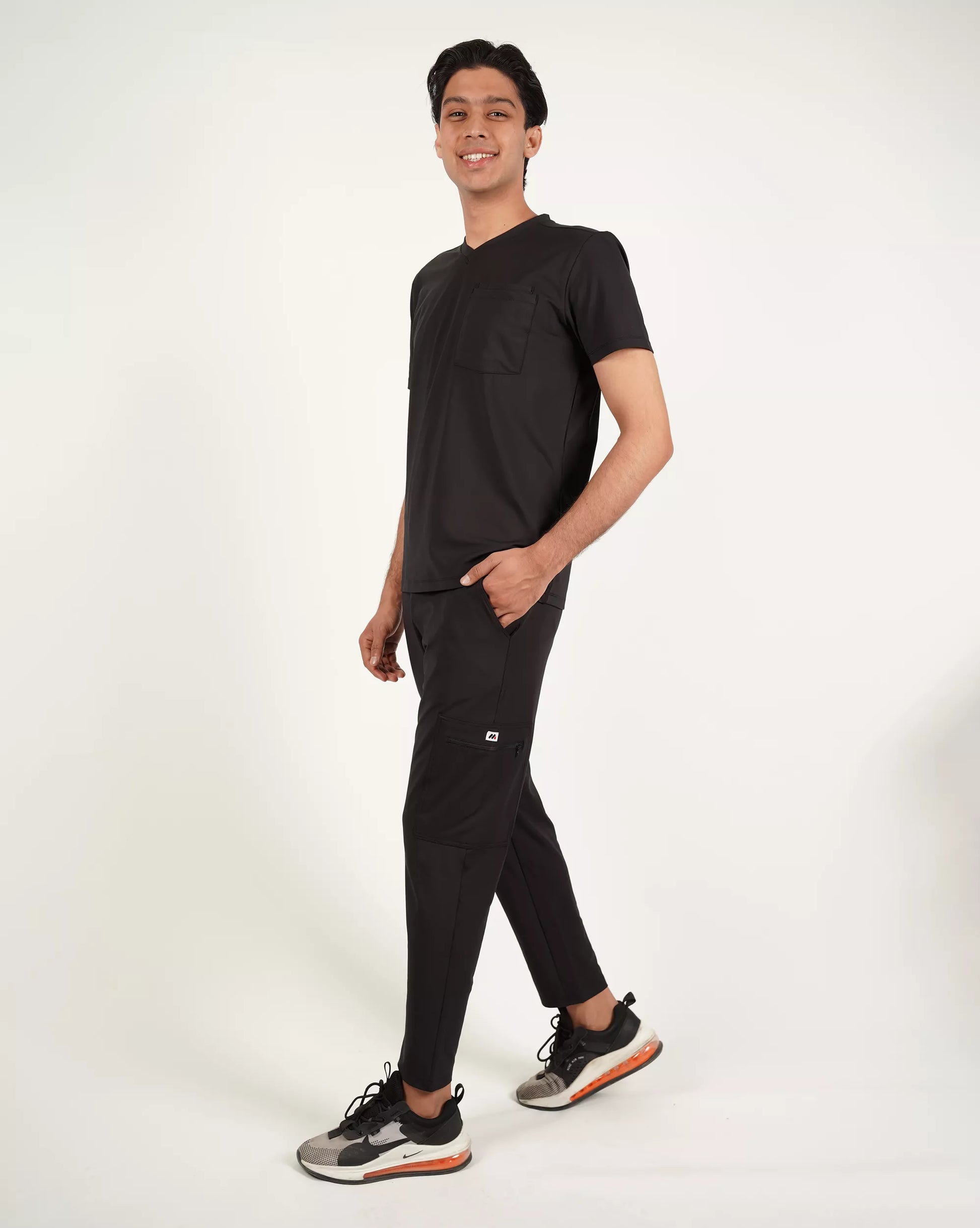 Person wearing a black outfit on a plain background