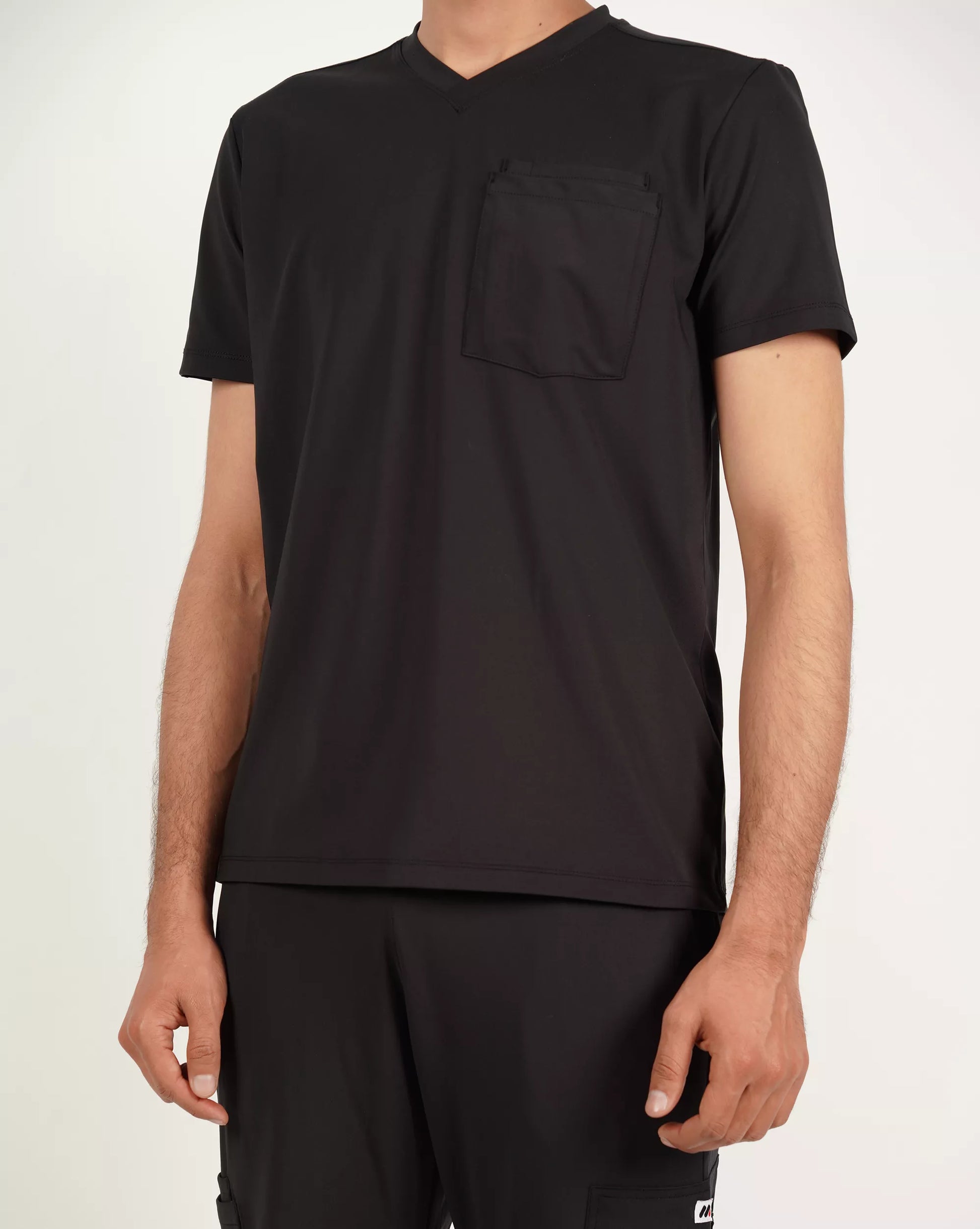Black t-shirt worn by a person on a plain background