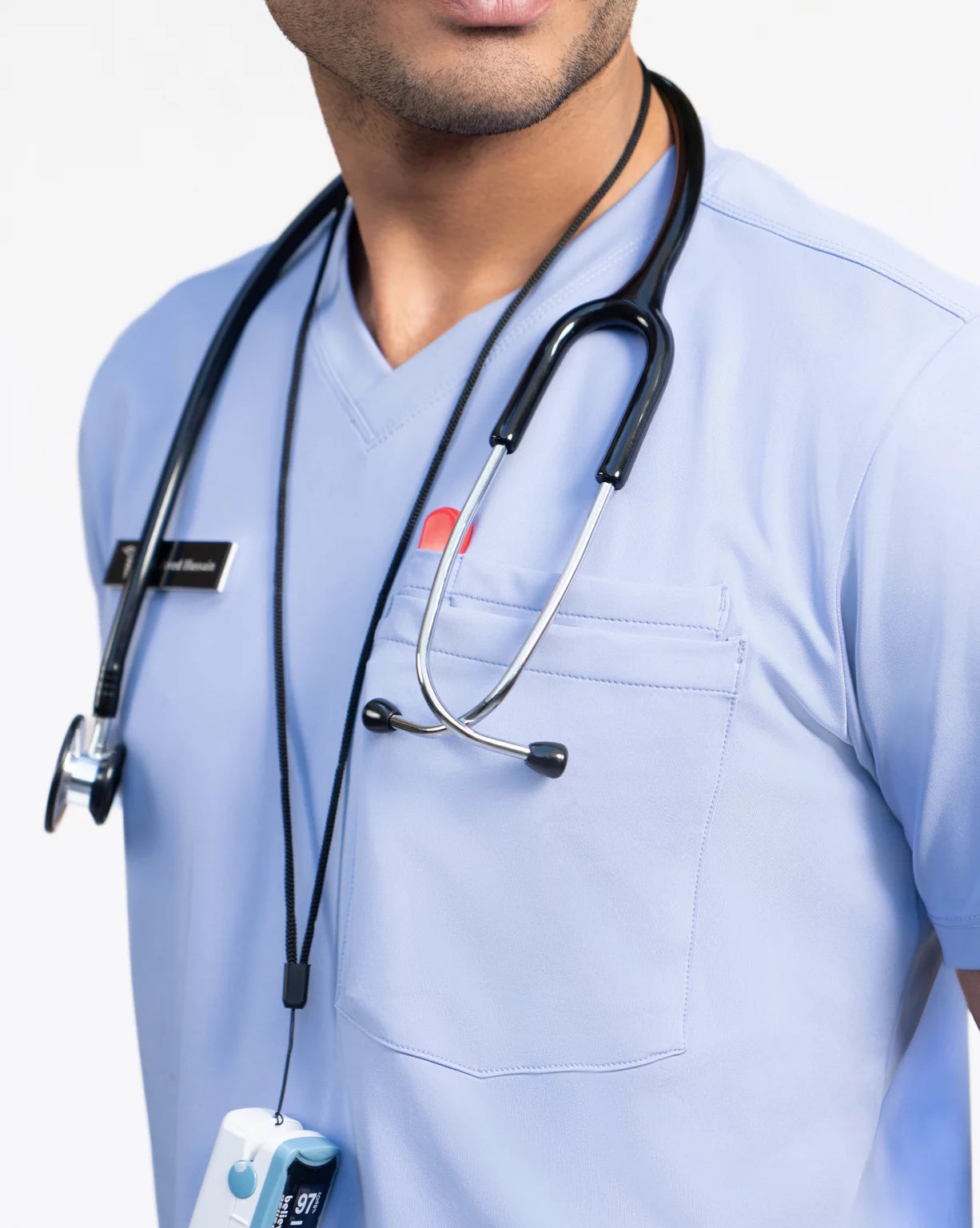 Person in medical scrubs with a stethoscope and device.