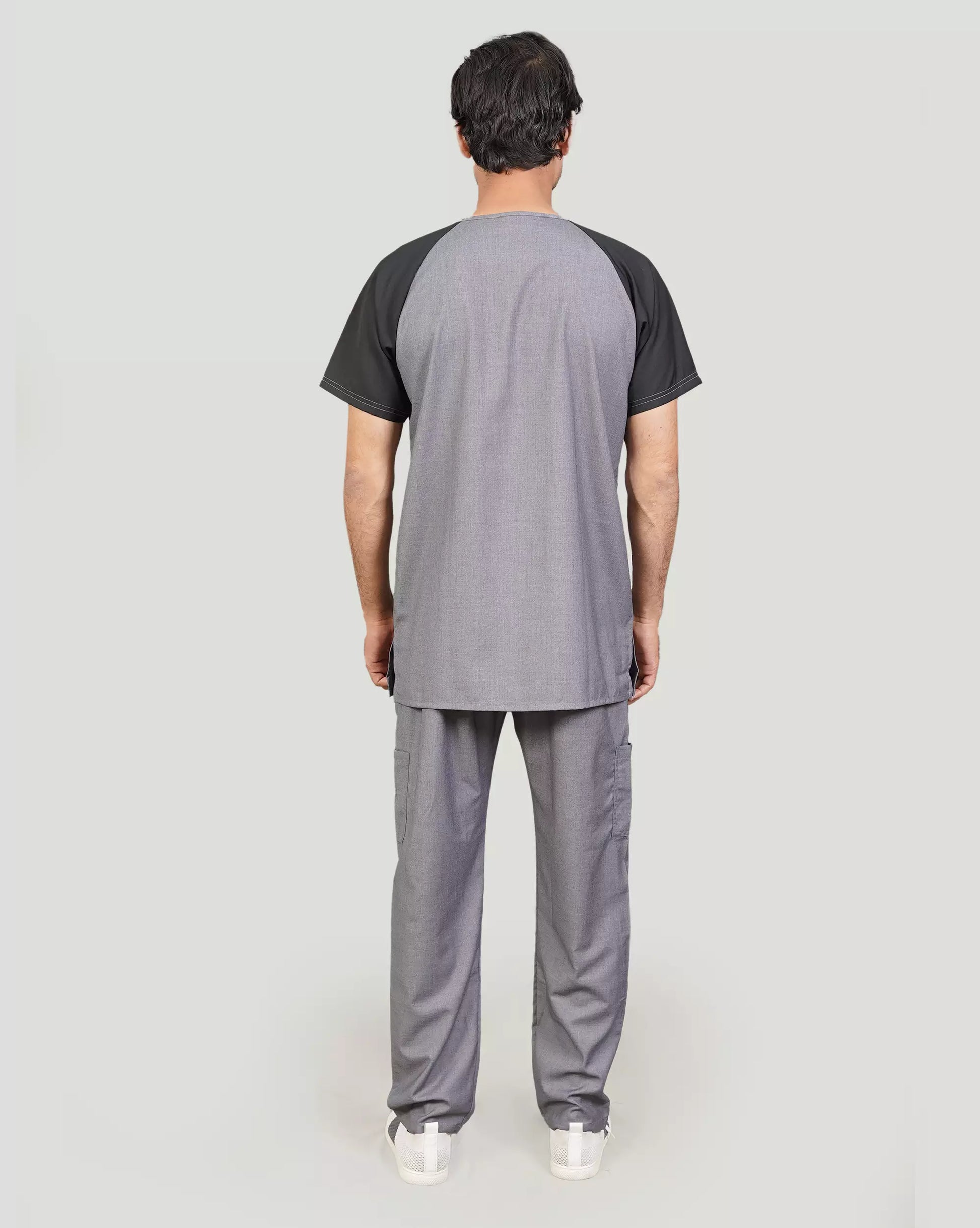 Person wearing a gray scrub set with black sleeves.