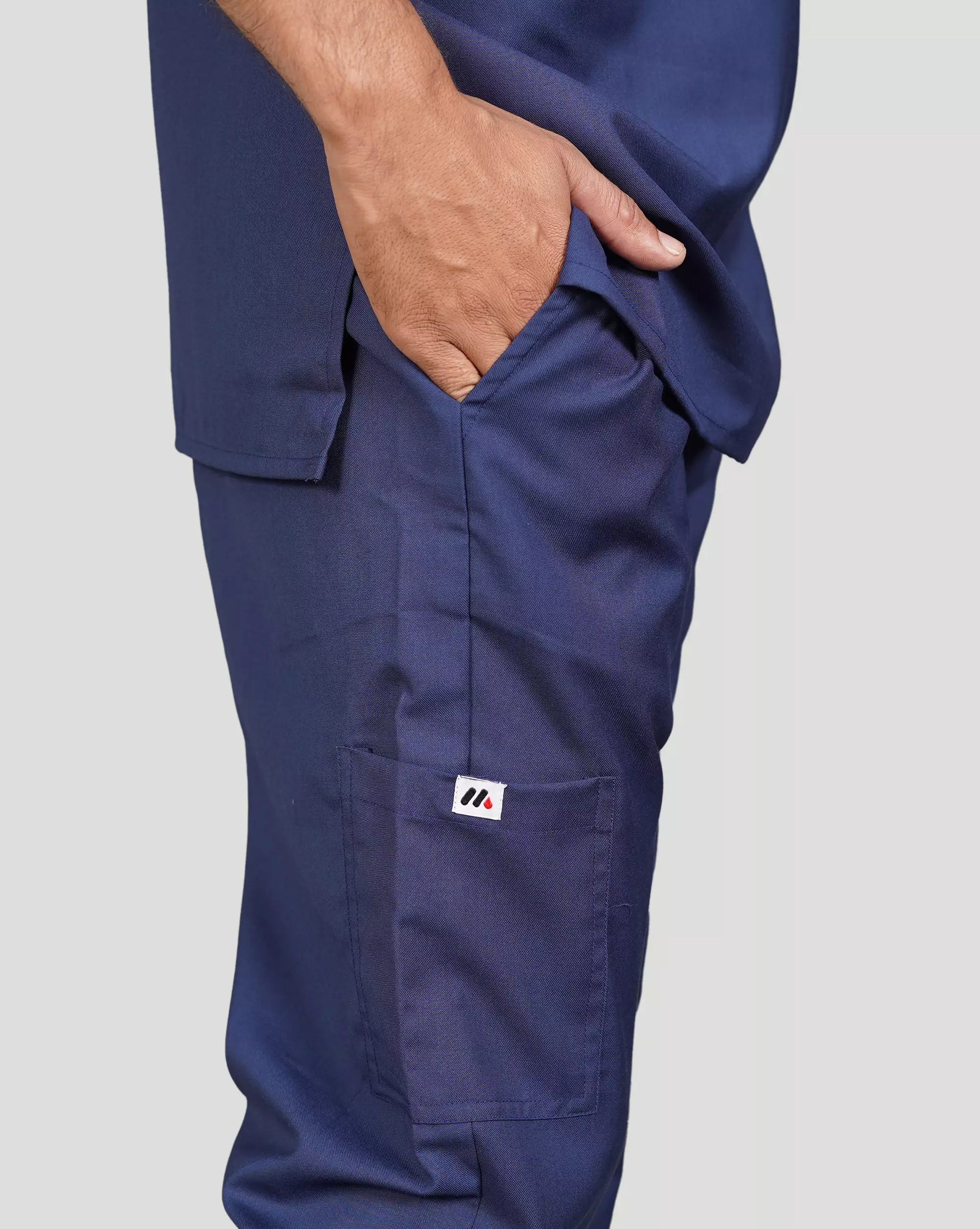 Navy blue scrub pants with a logo on the leg against a plain background.