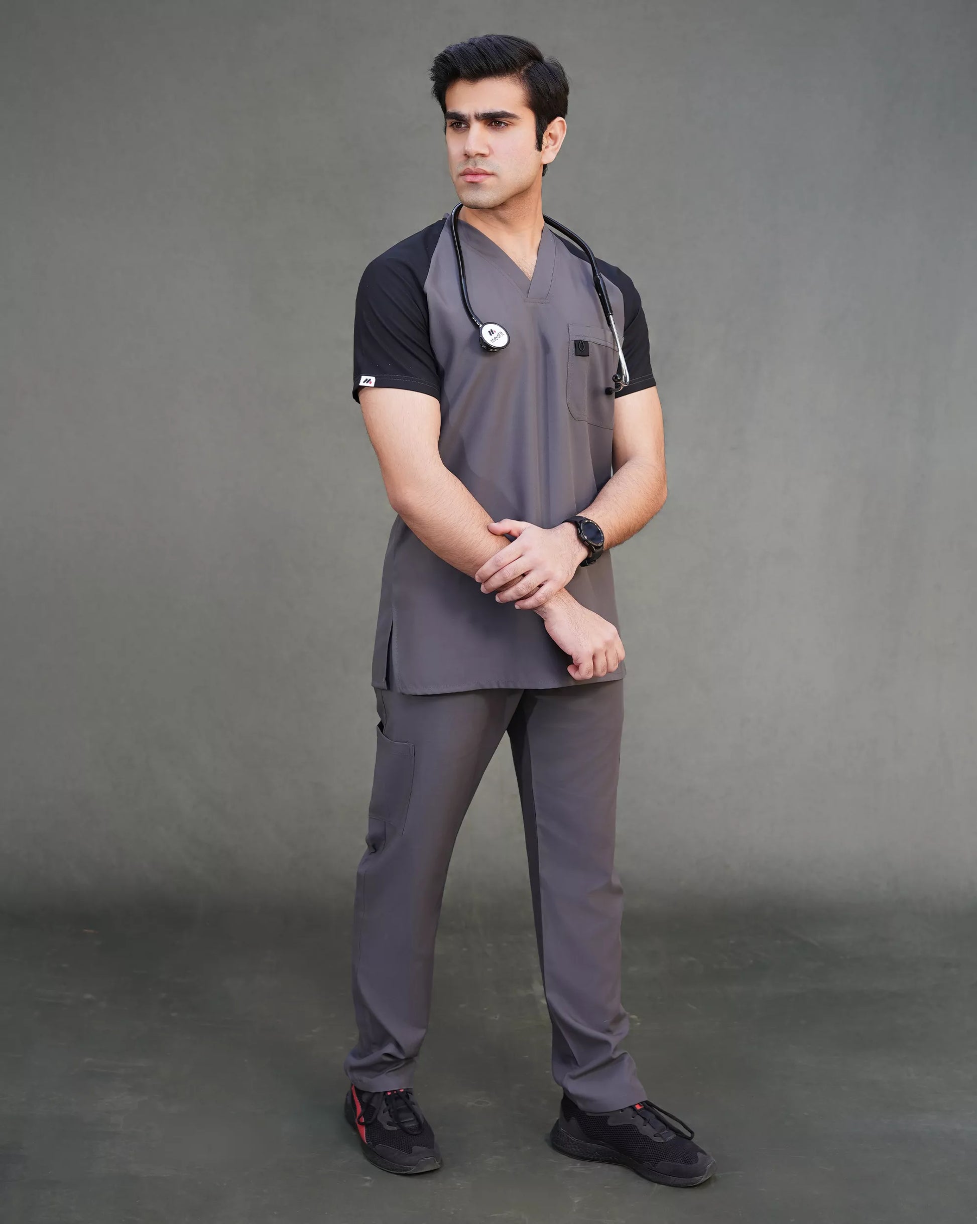 Person wearing gray Graphite Unisex Scrub against a gray background