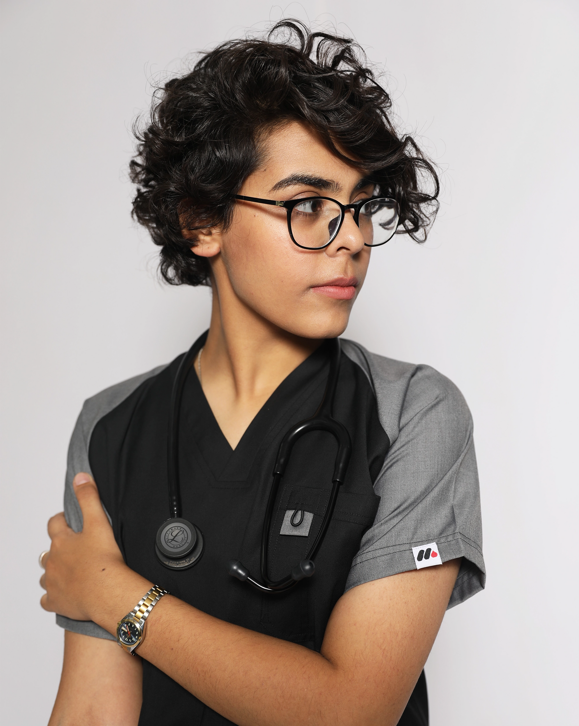 Person wearing medical scrubs with a stethoscope, looking to the side.
