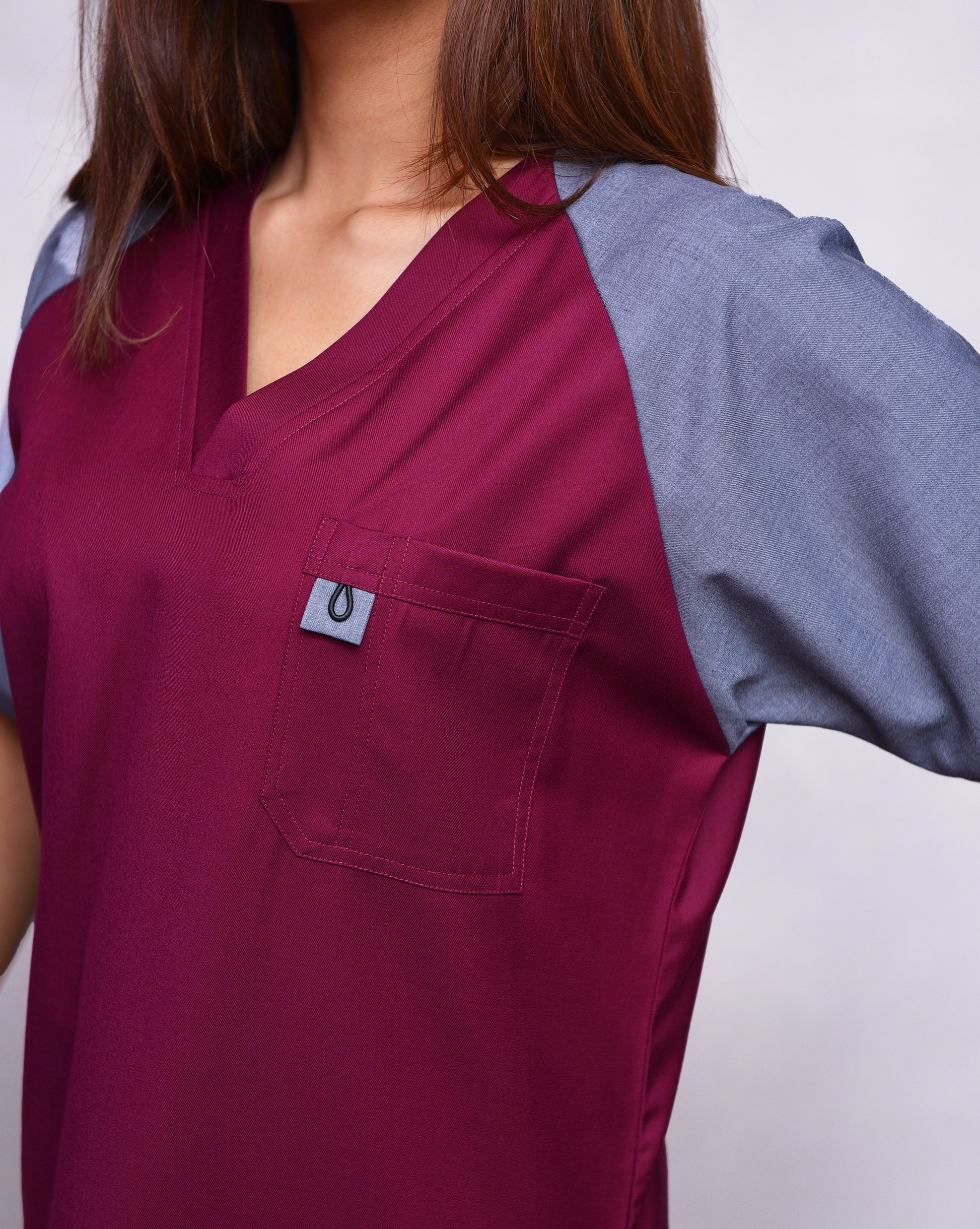 Maroon scrub top with a pocket and gray sleeve on a doctor.
