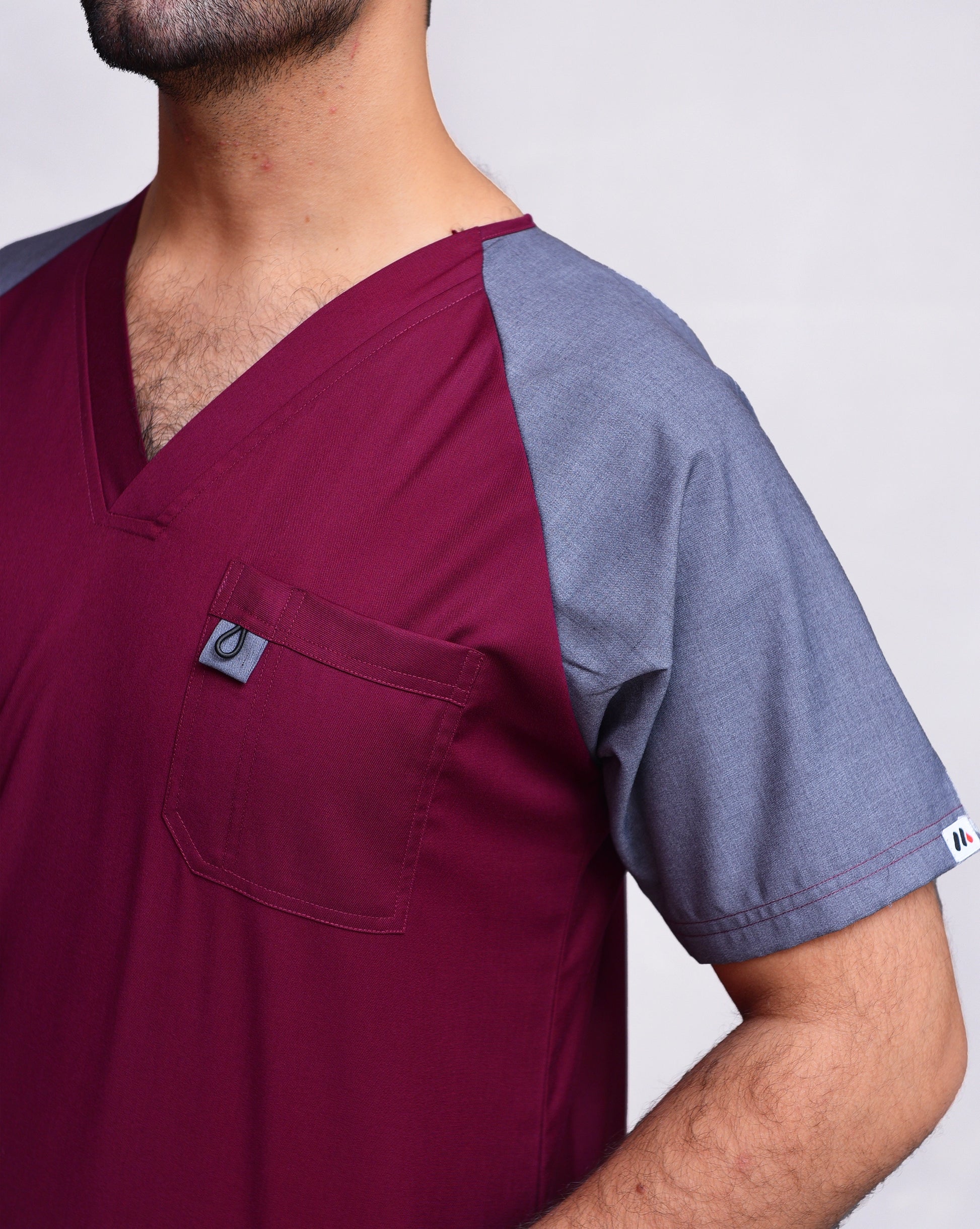 Two-tone scrub top with maroon front and gray sleeves.