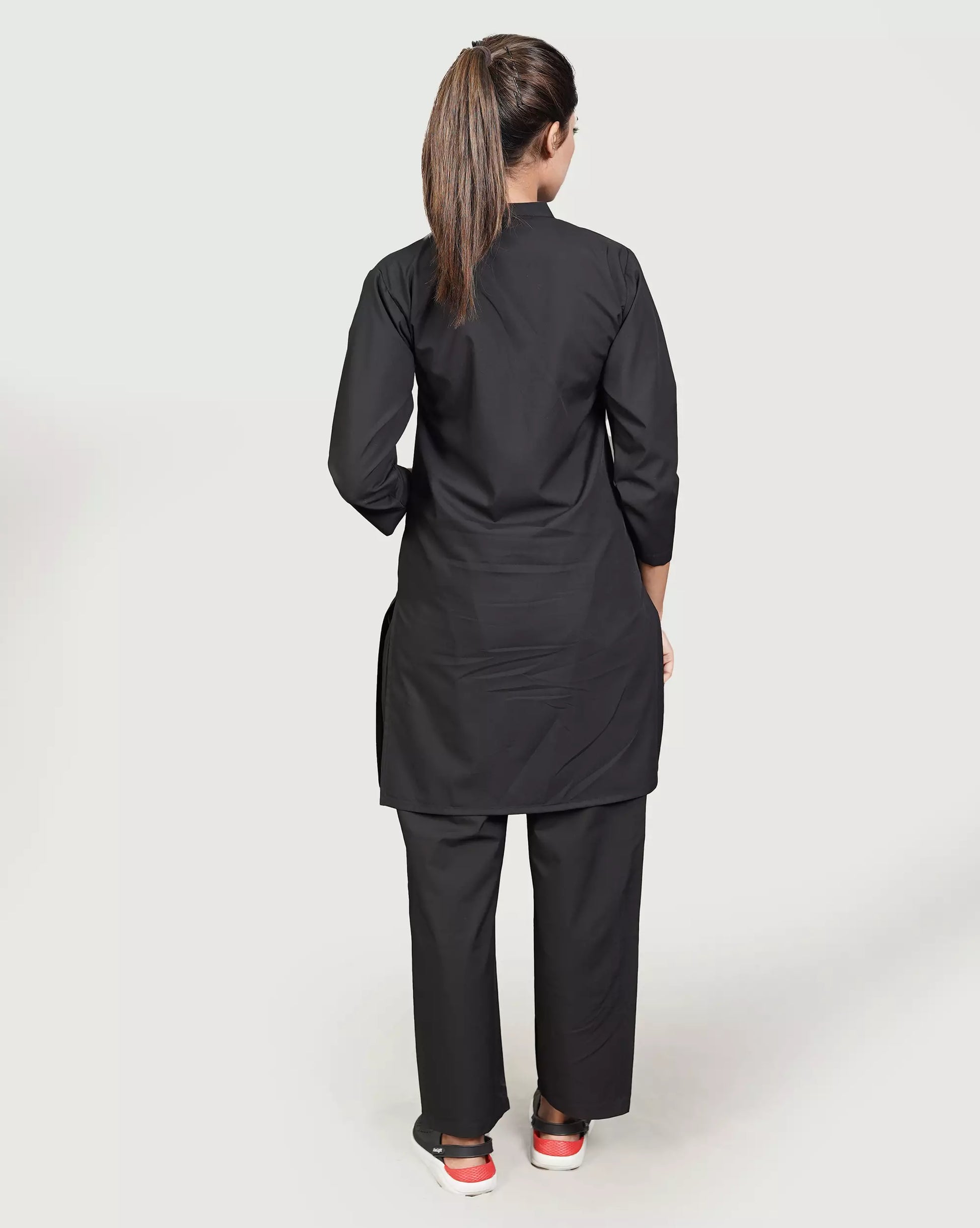Person wearing a black outfit on a plain background