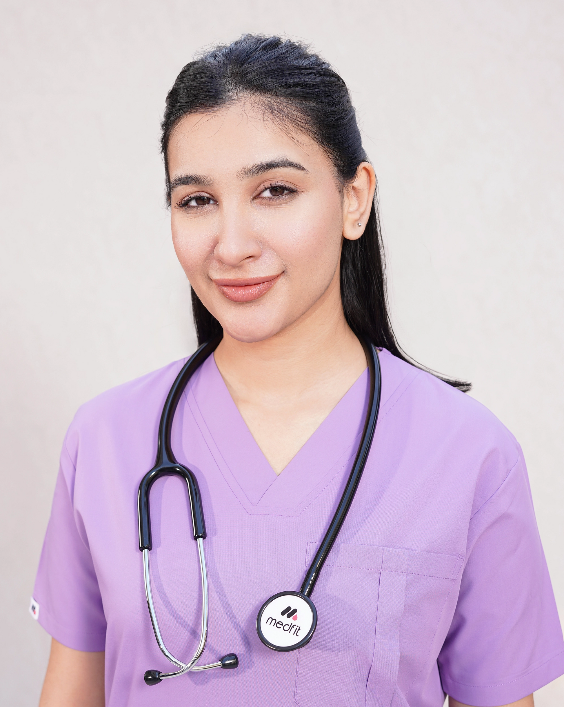 Close-up of a smiling female medical professional in a lavender Medfit Prime Unisex scrub top with a stethoscope, ideal for professional medical branding.